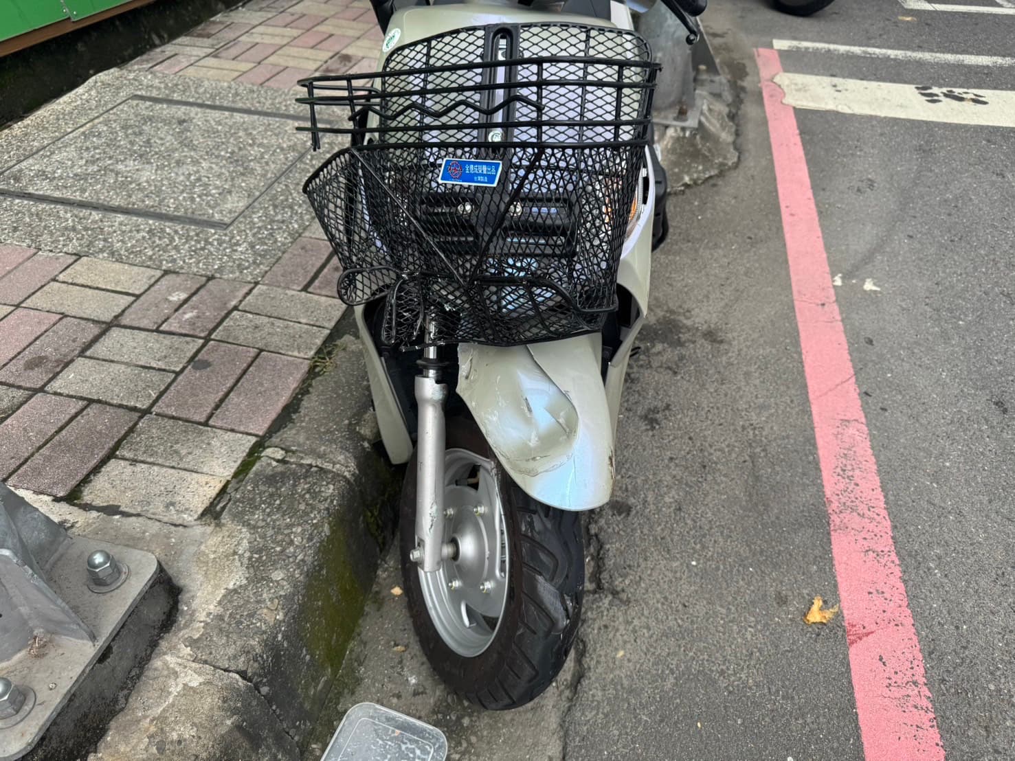 蔡姓婦人的機車遭撞，車籃整個變形。（翻攝畫面）
