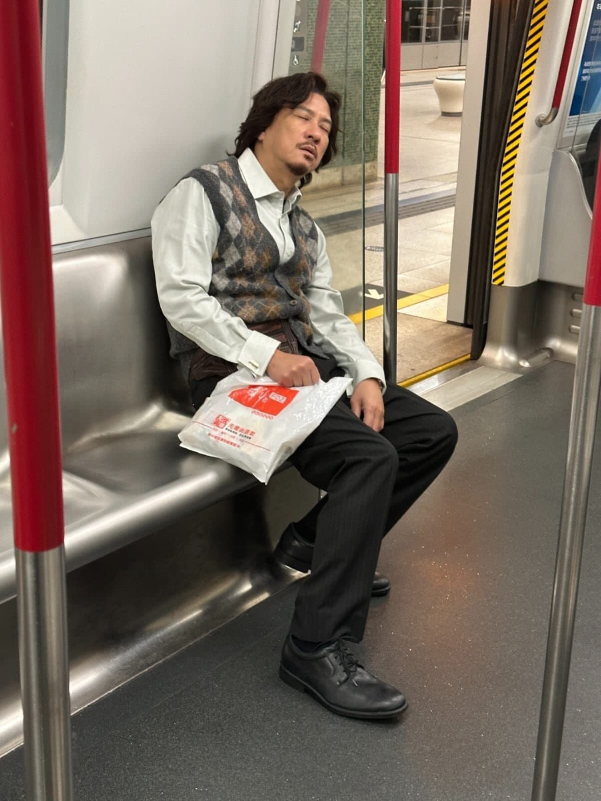 為了宣傳電影,張家輝打扮成片中角色「蔡辛強」的模樣在地鐵上累到睡過頭,故意被網友偷拍。(甲上提供)