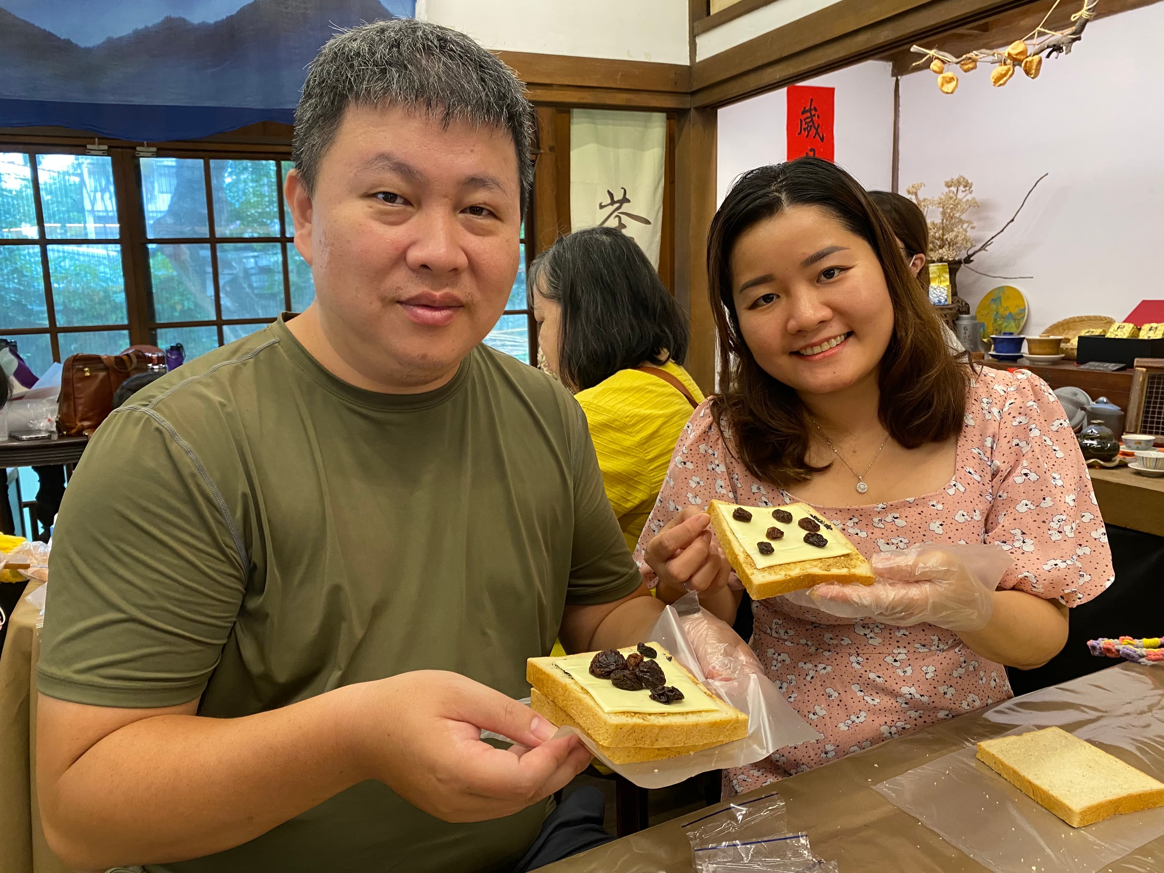 越南新住民紅青(右)和丈夫開心地展示手作健康三明治。(移民署提供)