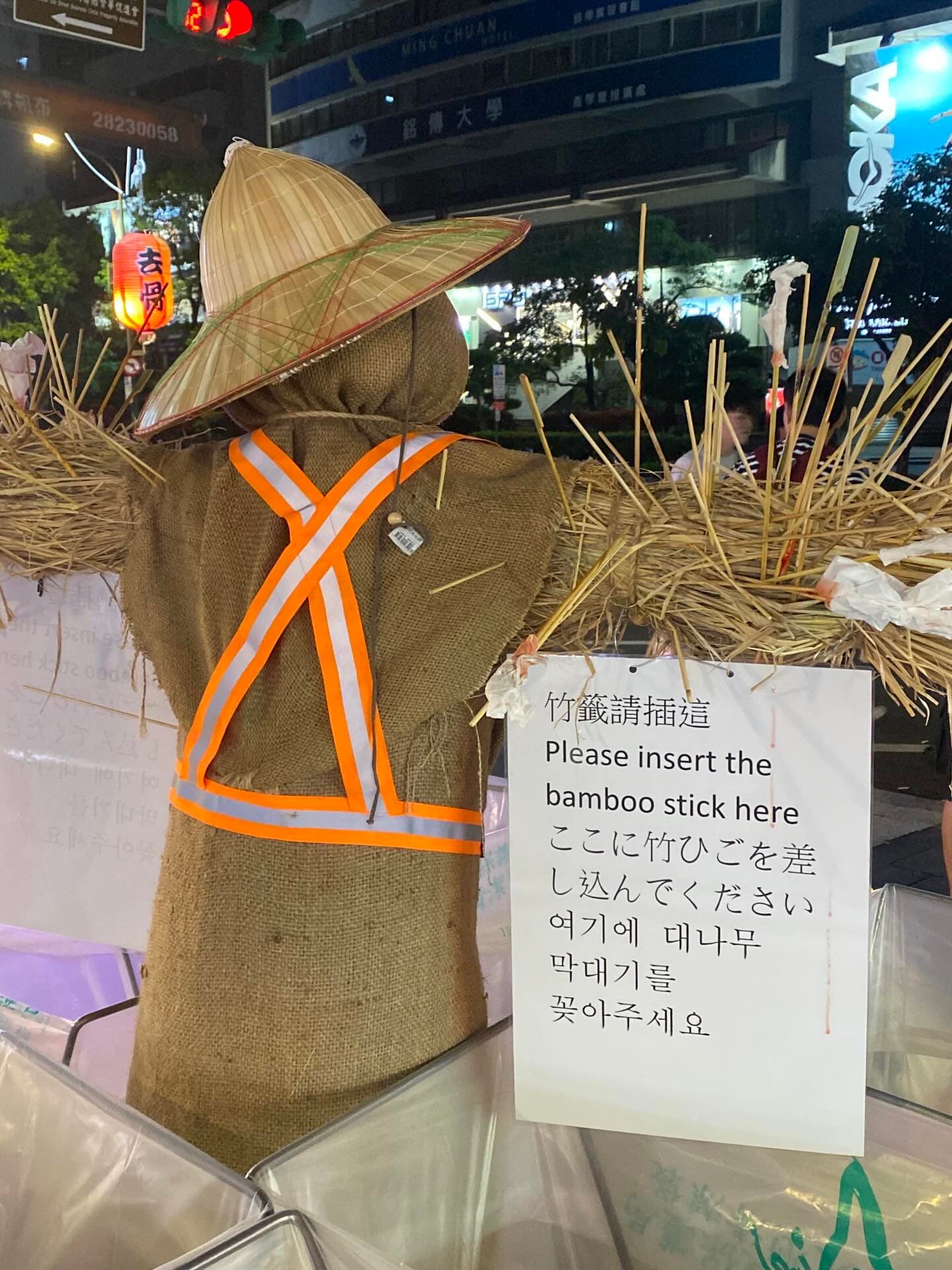 士林夜市在垃圾桶旁設置稻草人,呼籲民眾將食用完畢的竹籤插在稻草人身上。(翻攝threads@eeeeeesther6)