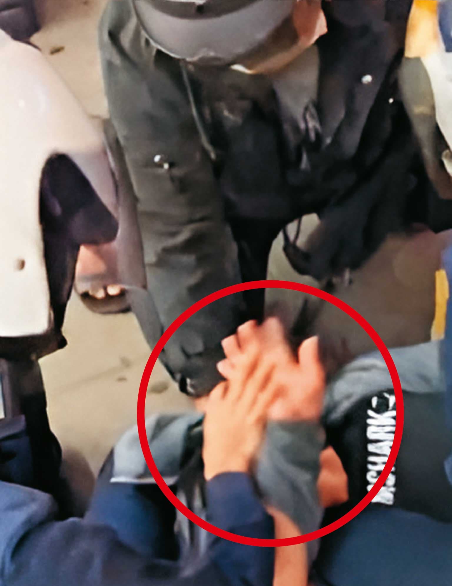 黃先生被壓制後,洪姓女警仍硬拗他的手指(紅圈處),害他肌腱當場斷裂。(讀者提供)