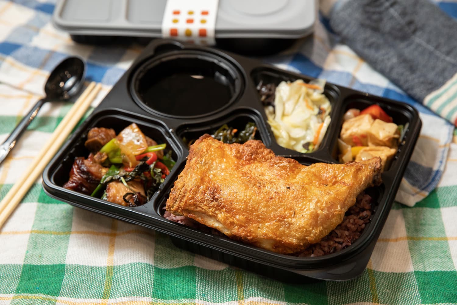 施俊豪特別設計的二代店便當盒可防漏,也可微波,飯、菜、甜湯壁壘分明,雞腿便當有雙主菜,菜色均少油、少鹽,相當受竹科工程師歡迎。(155元/個)