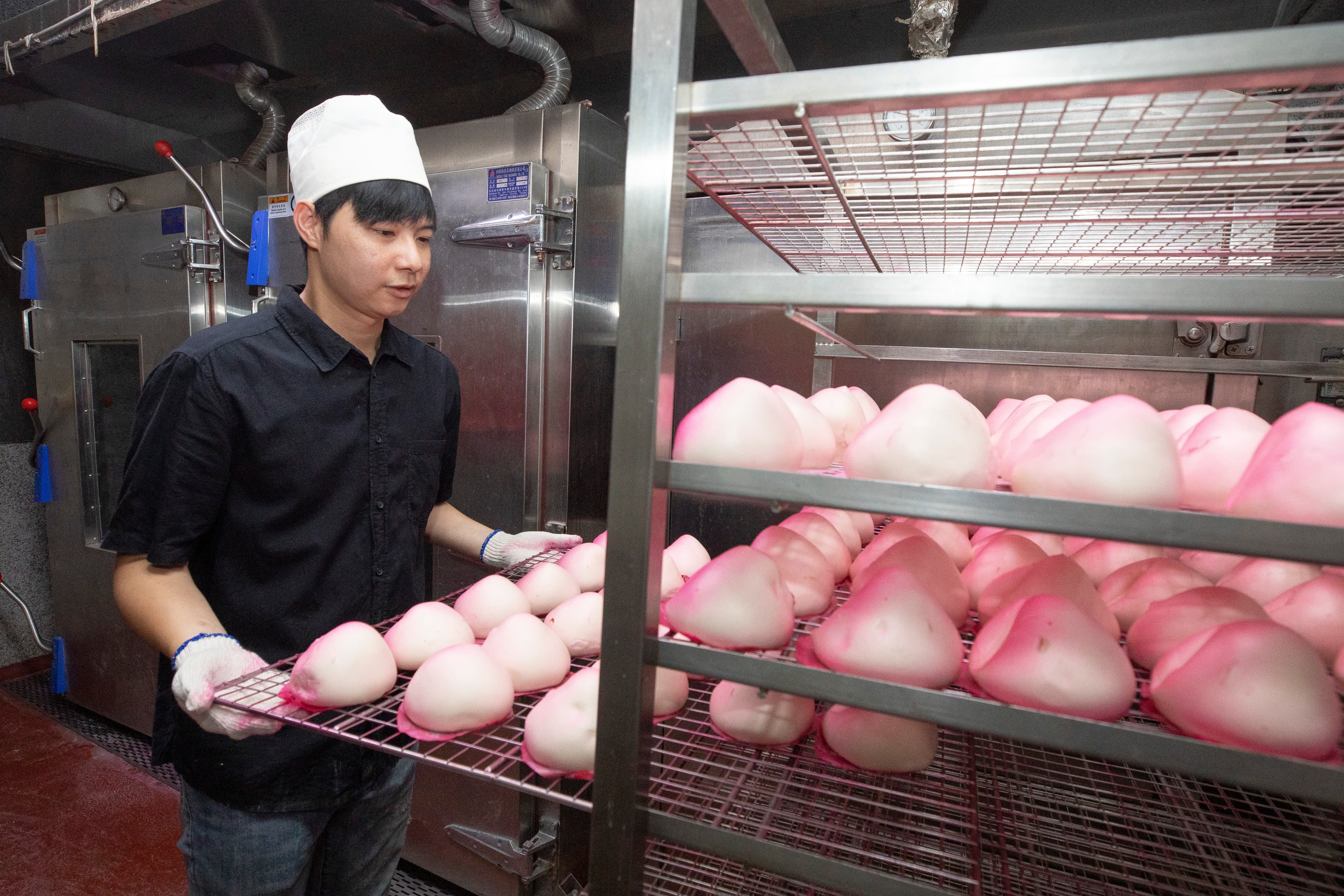 壽桃製作費工，蒸好後需一顆顆壓成桃子造型，再均勻噴色，是十字軒招牌商品。（30元／顆）