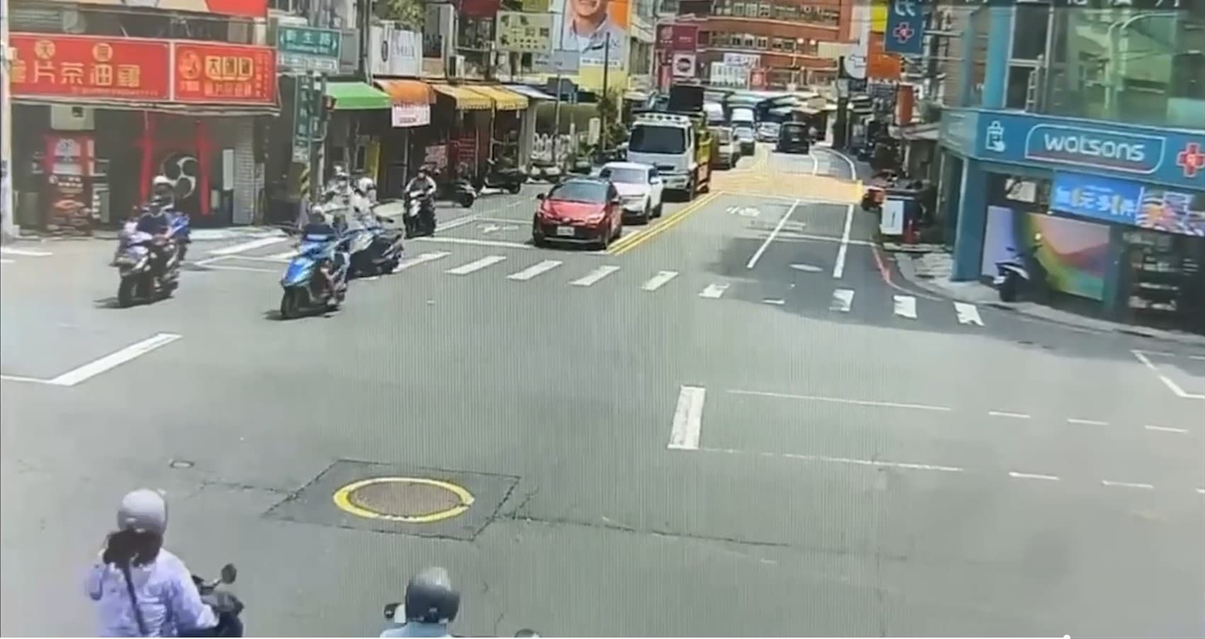 女騎士打電話報警時，許男趁著路口燈號轉綠，直接騎車逃逸。（翻攝畫面）