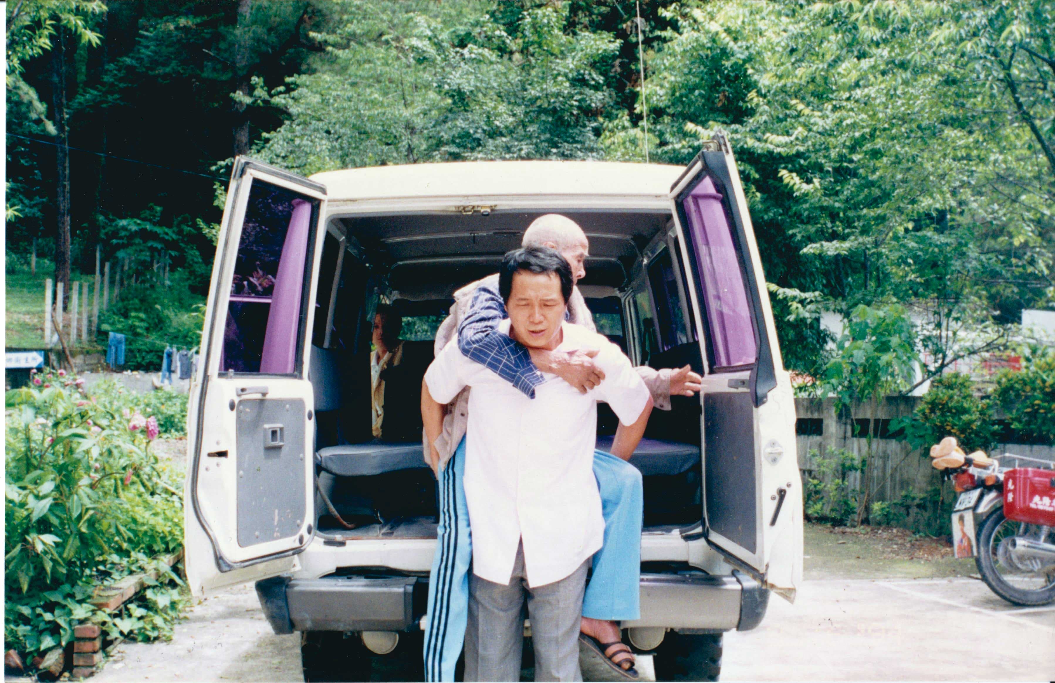 深山行醫資源不充足,賴力行(前)親力親為,還會自己背著年長病患移動。(賴力行提供)