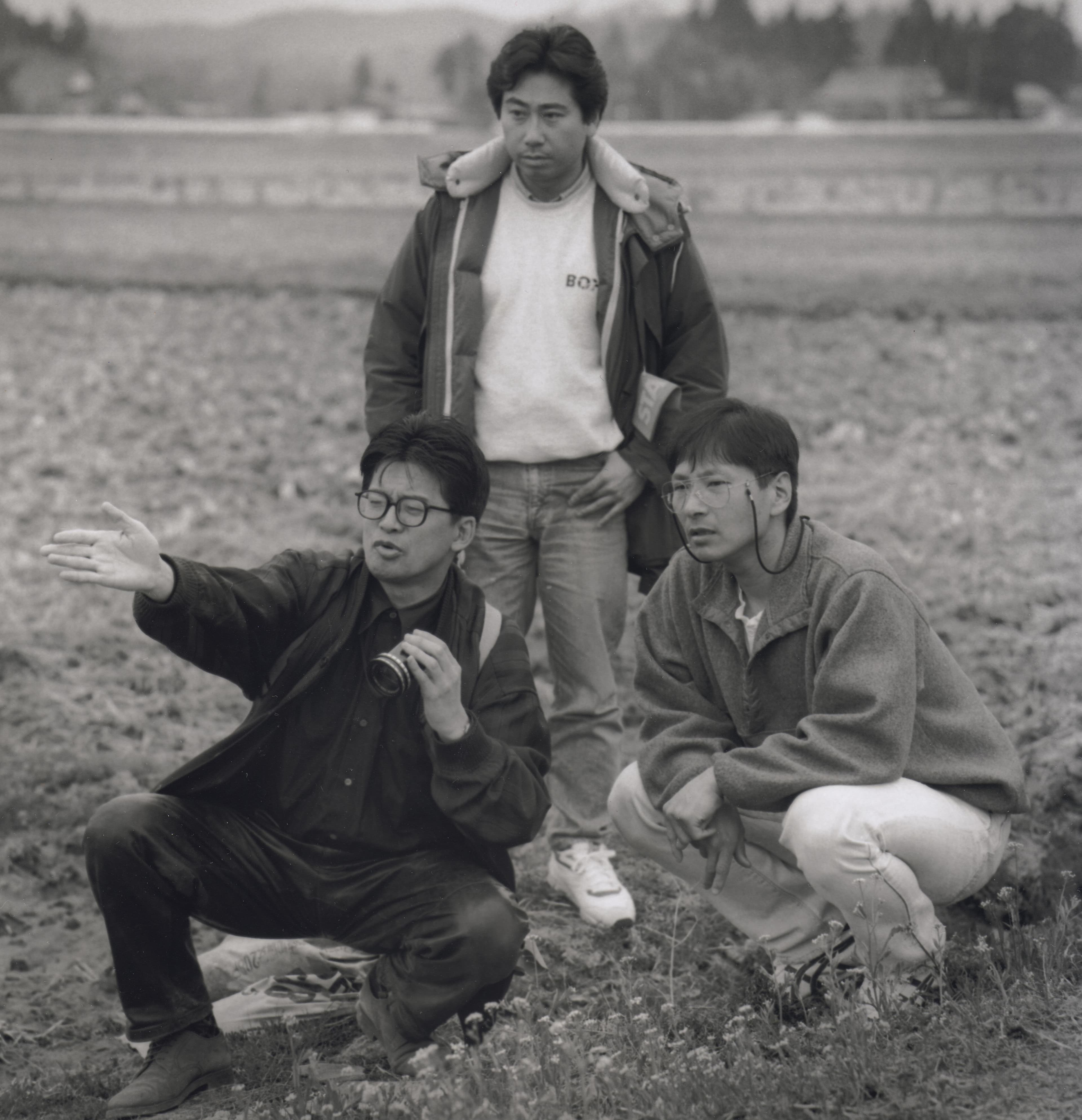 森田芳光(前排左)與工作人員為拍攝《春天情書》的一場戲外出取景。(高雄電影節提供)