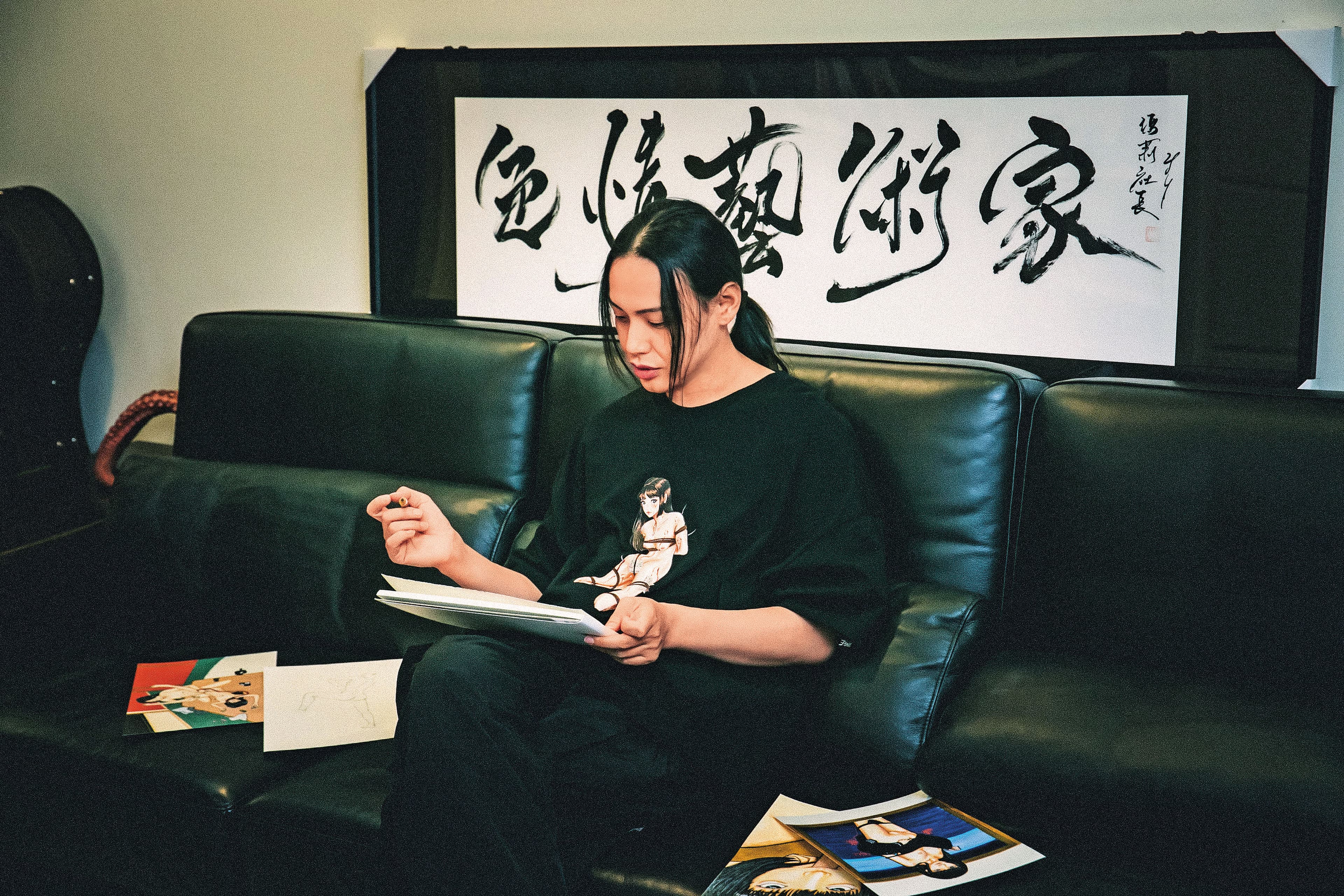 小艾坐在客廳專注畫畫。他說,色情藝術應該要有更高的價值。