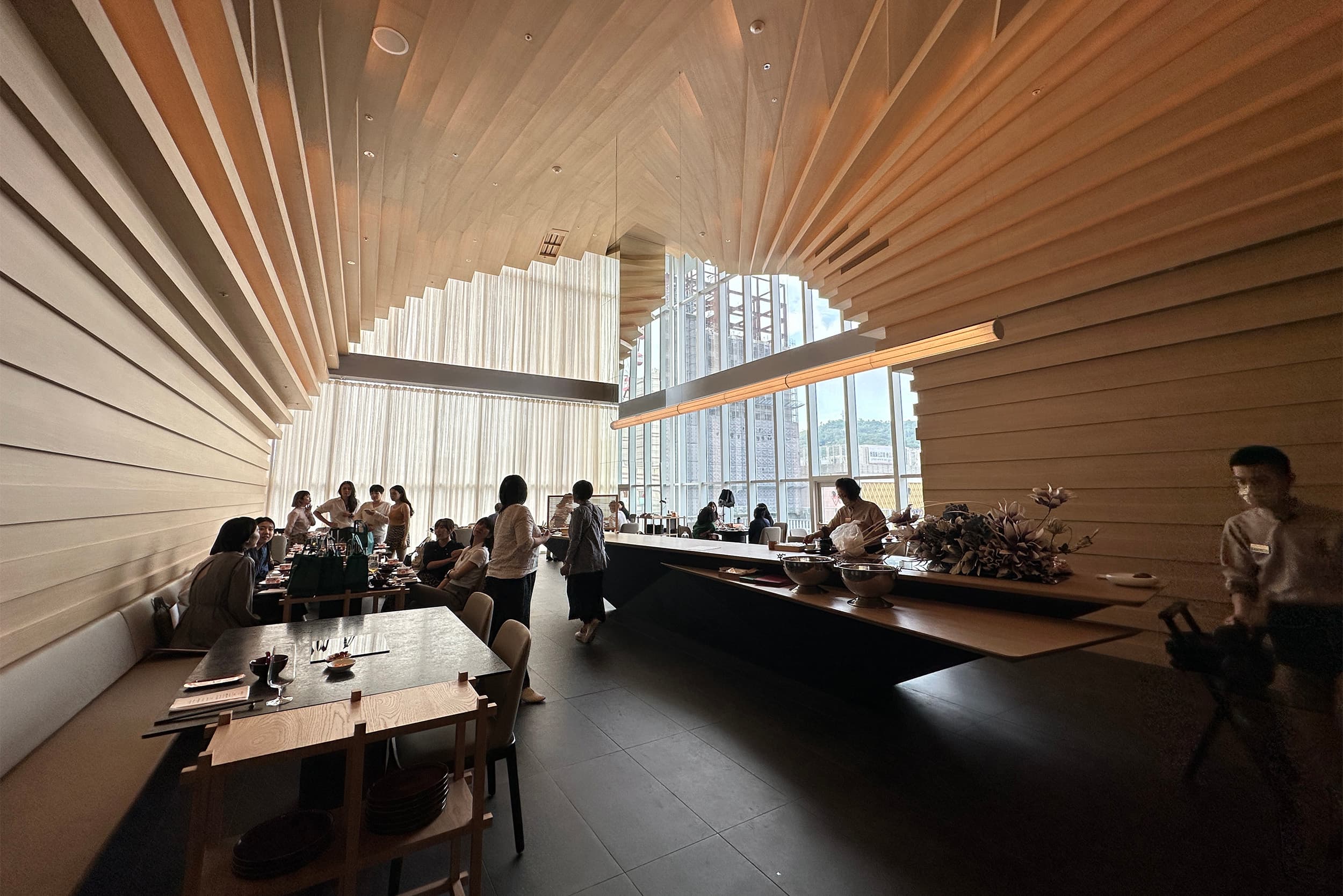 餐廳空間以大量木質建材為主軸,營造有如置身巨大天然海蝕洞中的包覆感。(童心怡攝)