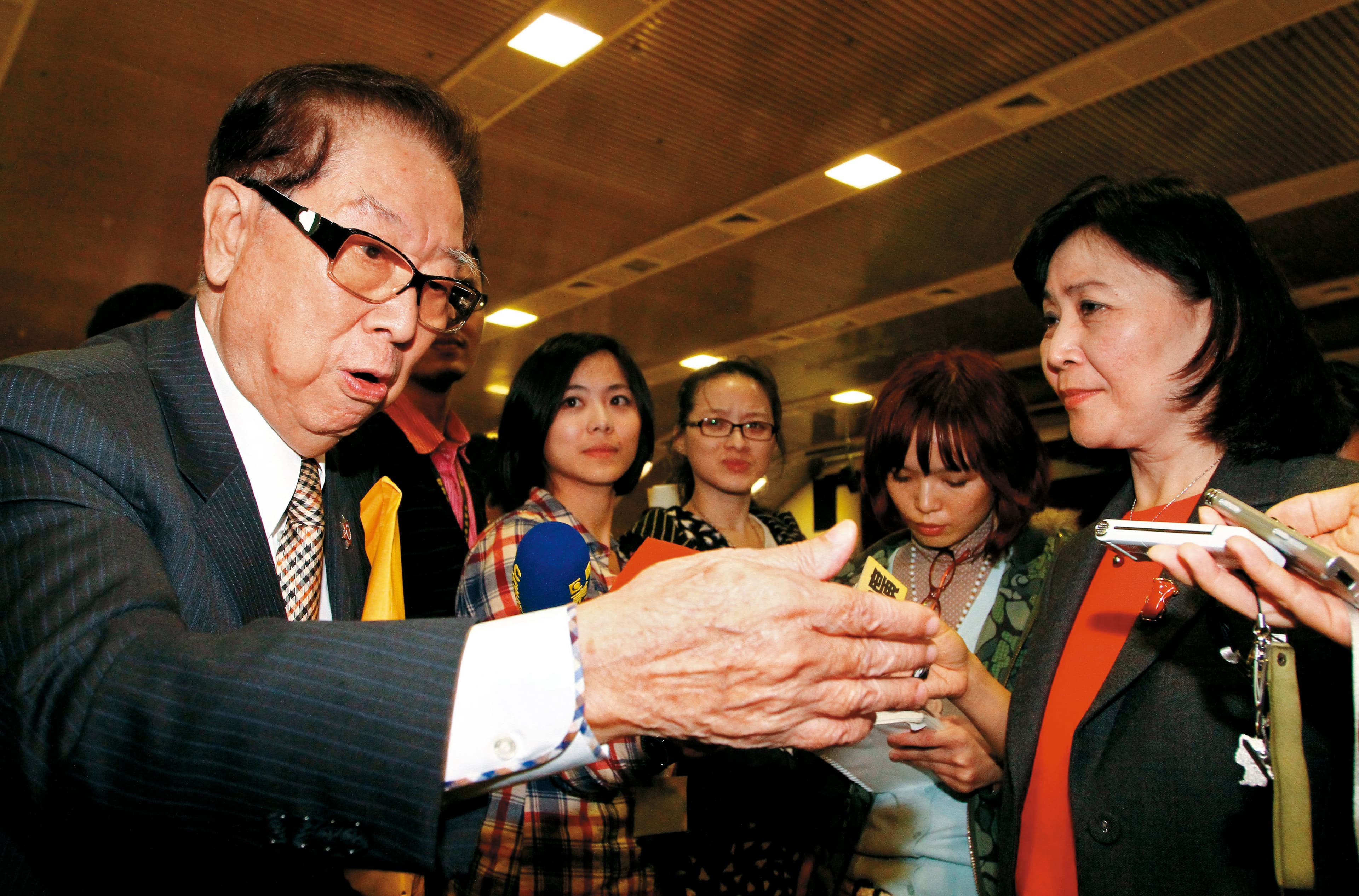 2012年財政部長劉憶如(右)推出新版證所稅方案,阿土伯(左)大聲反對。(聯合知識庫)