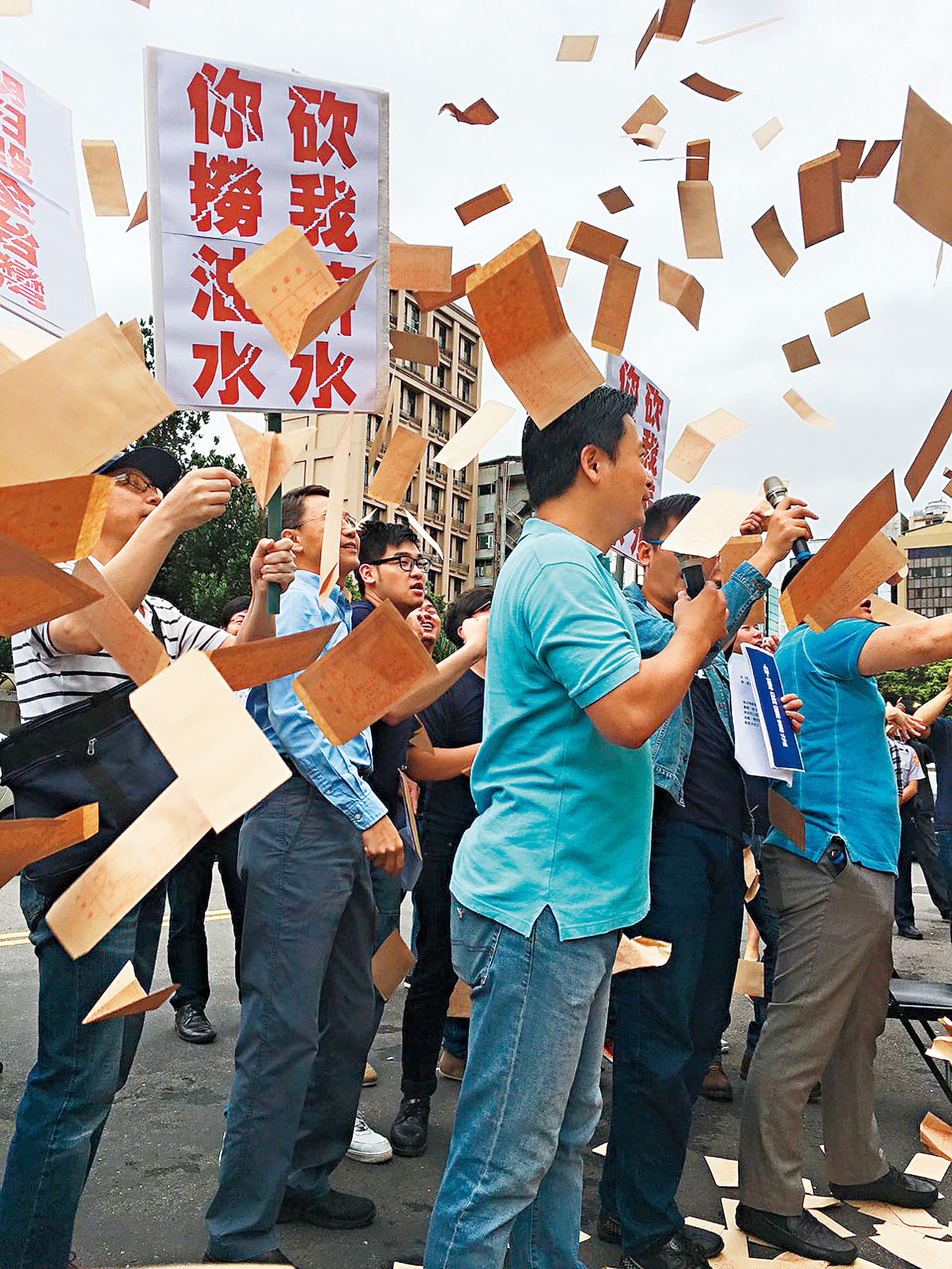 國民黨黨工遭積欠薪資相當不滿,十三日到黨產會前丟薪資袋抗議。(中央社)
