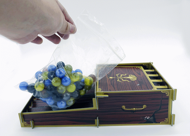 遊戲準備時,將彈珠倒入「成分供應機」的示範(GIF來源:BoardSheep小羊桌遊報)