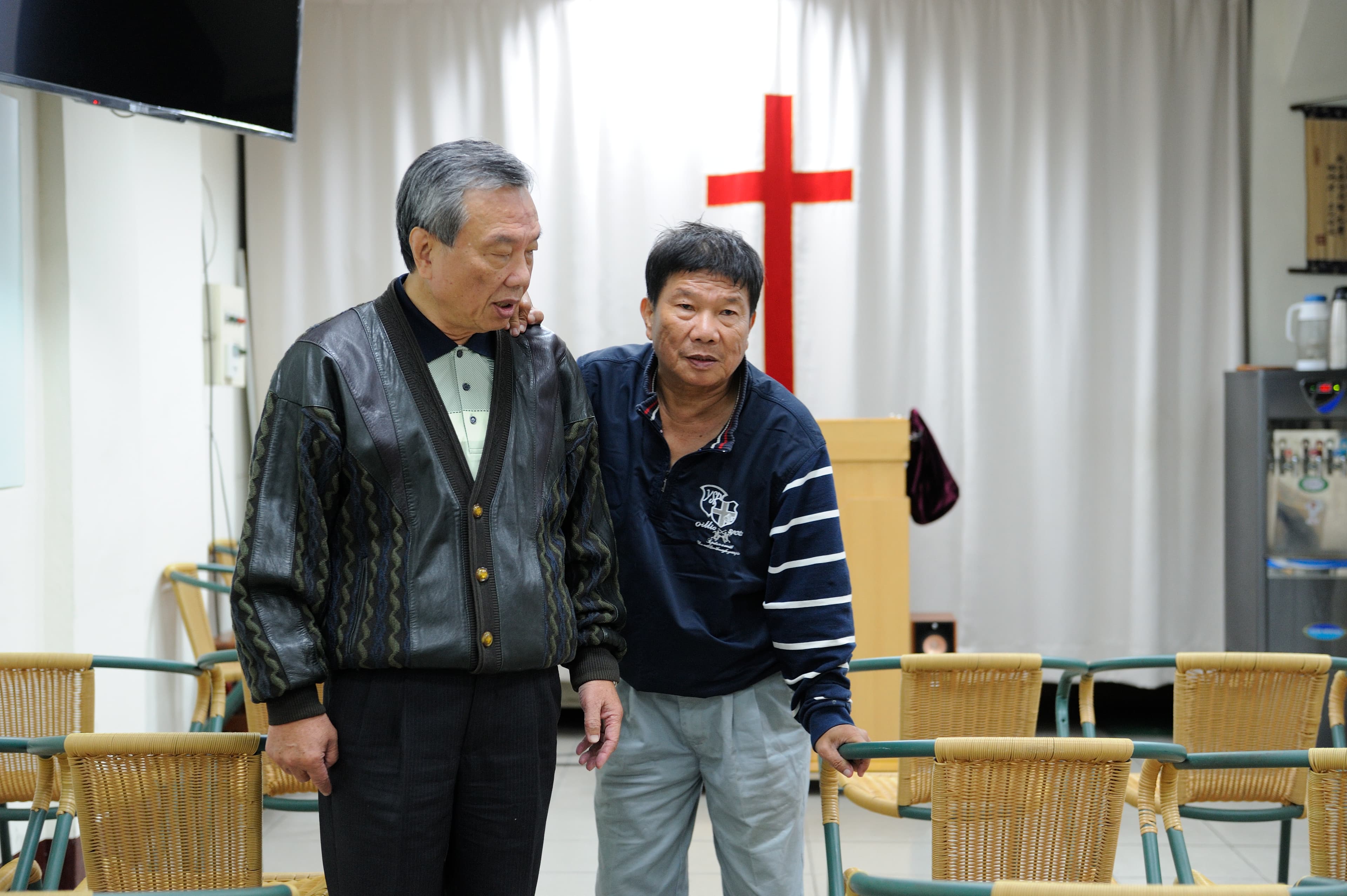 李垂欣(右)在哥哥李東原(左)影響下信教,採訪這日哥哥陪他上教會,行動不靈活的他搭著哥哥的肩慢慢行走。
