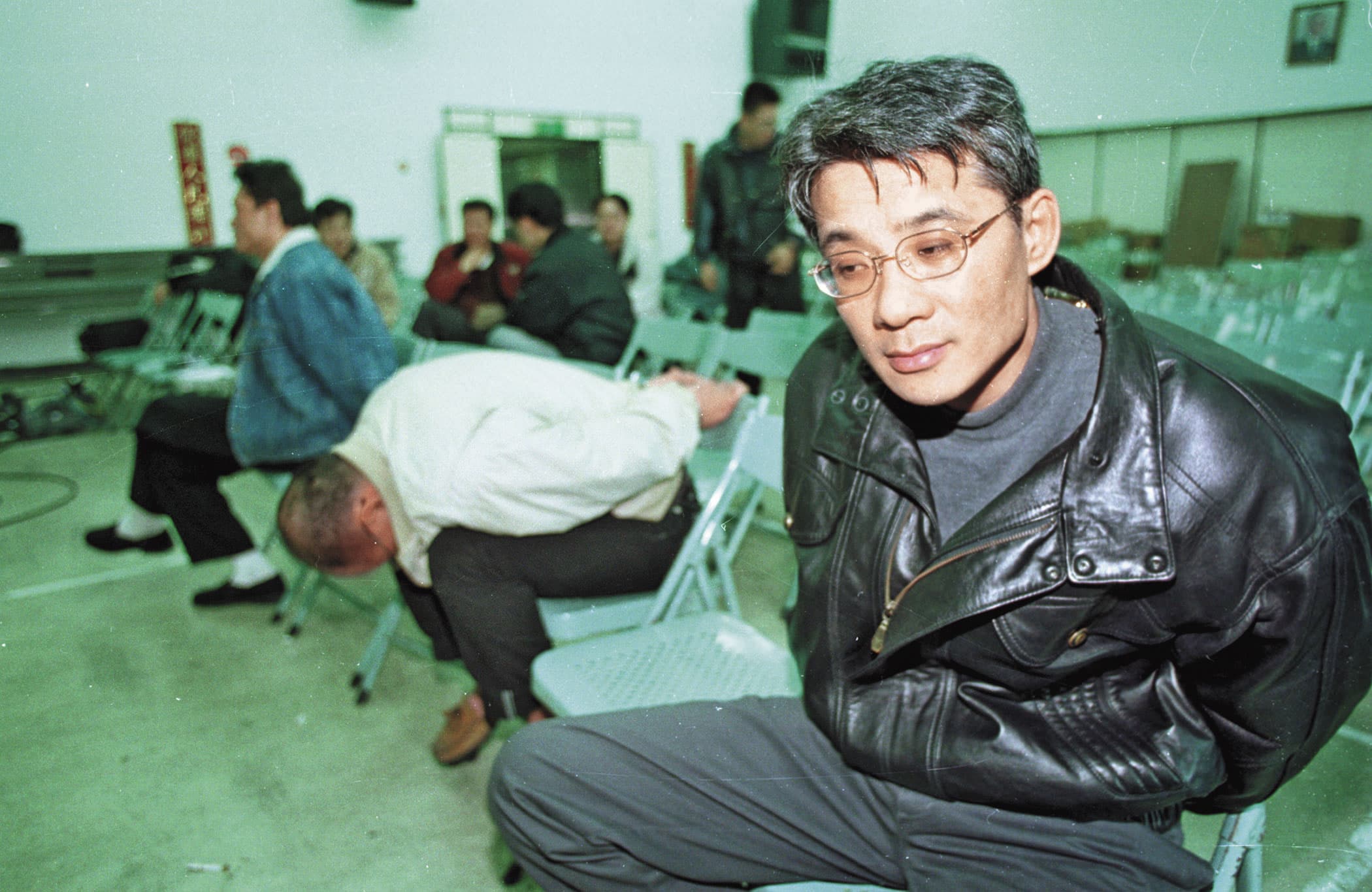 1999年,黑金城(右)2度被捕,面對隨之而來的牢獄之災,他神情無奈。(中央社)