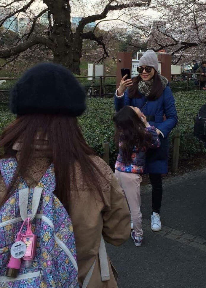 郭董夫人曾馨瑩在櫻花林自拍，女兒則依偎在她身上撒嬌（讀者提供）