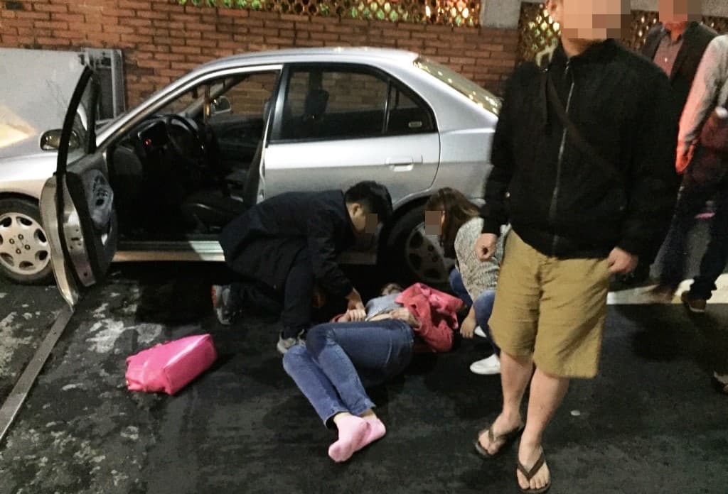 路人見林女上半身遭輾、失去意識,立即合力抬車協助脫困。