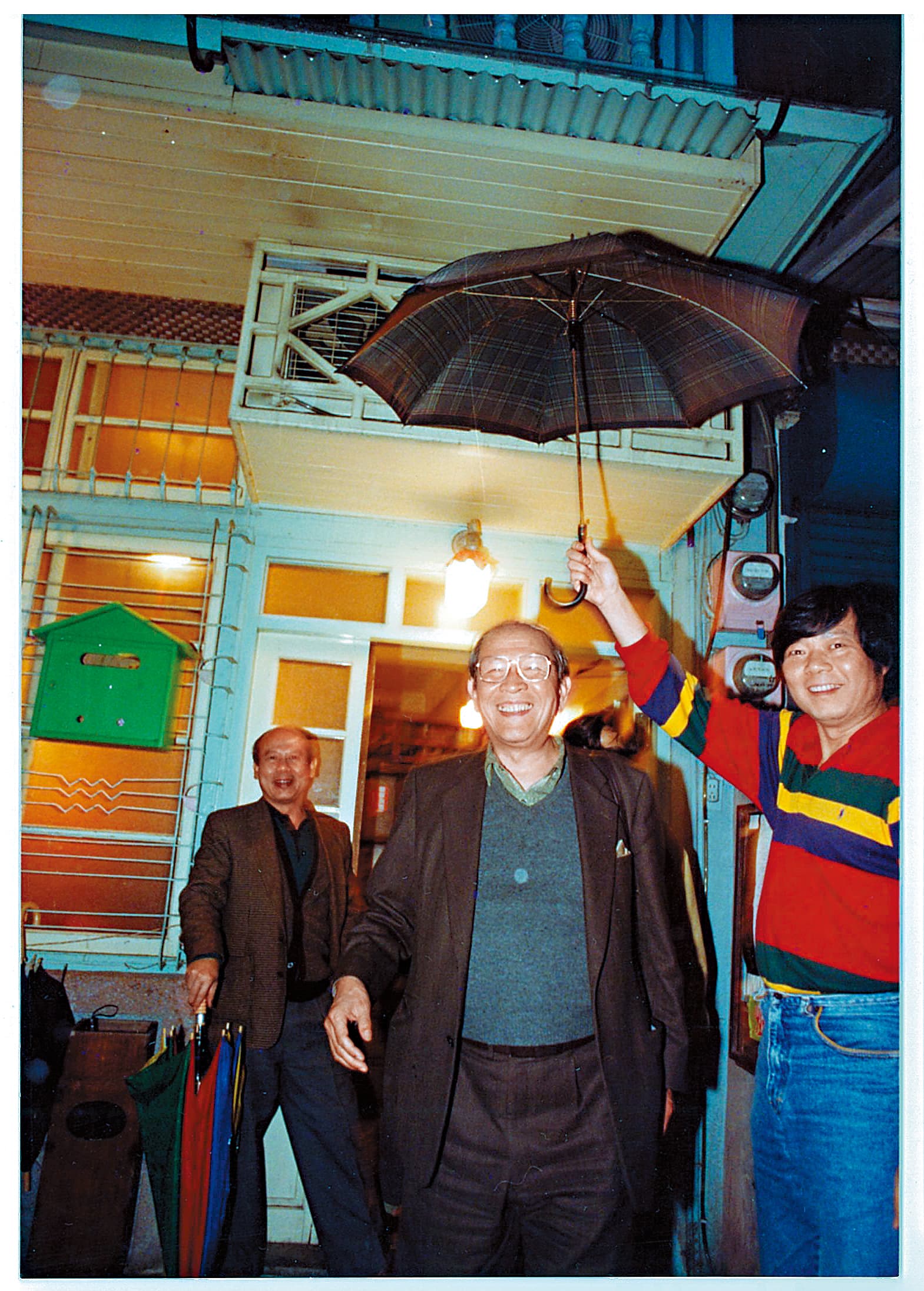 阿才的店一直是黨外運動人士聚集場所,第一代老闆阿才(右)幫台獨聯盟主席黃昭堂(左)撐傘。(余岳叔提供)