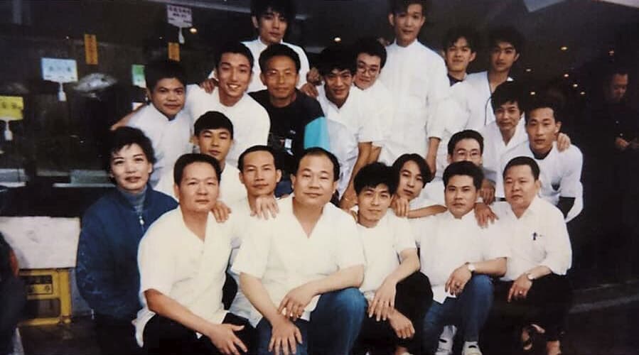 約20年前黃文童(圖中深藍色上衣)將店搬至汀州路上時的店員合照,直到現在,多數員工都仍在崗位上服務。(黃文童提供)