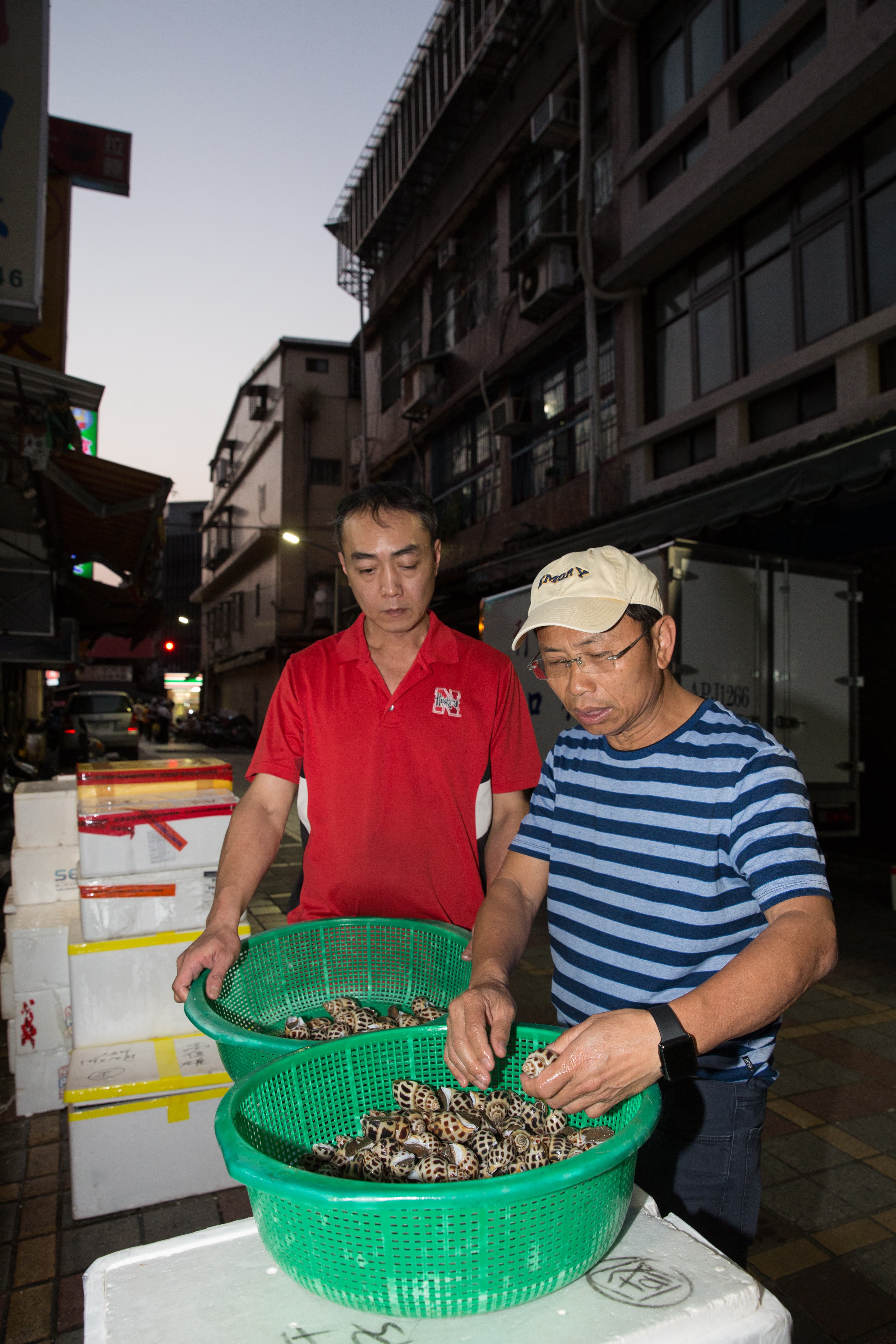 每日清晨5點，黃文童（右）都會去三水街市場上的海鮮供應商挑貨，以確保食材符合自己對新鮮度、規格的需求。
