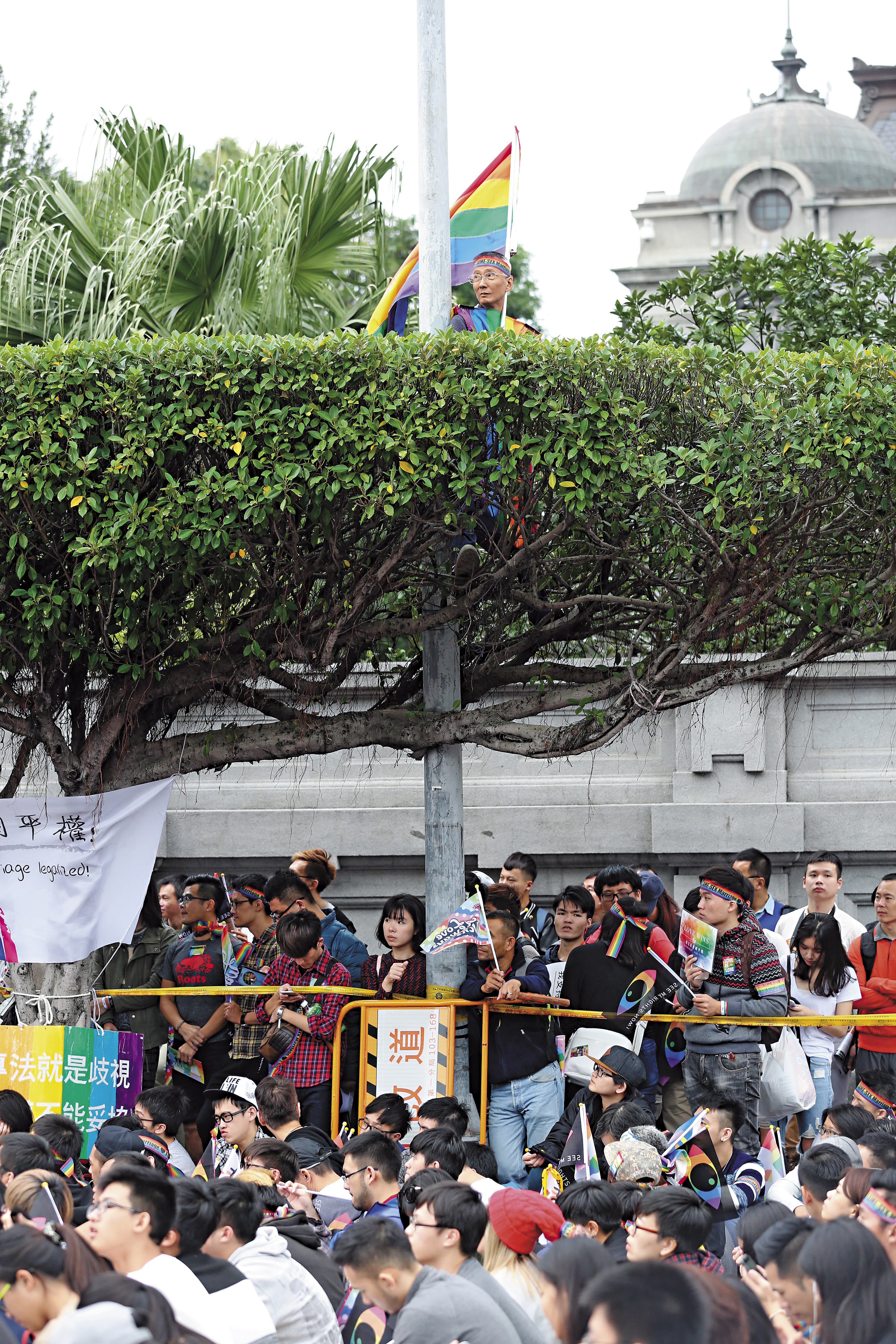 每年同志遊行或相關活動，祁家威皆手持彩虹旗，甚至身穿彩虹衣，站上制高點。（賴智揚攝）