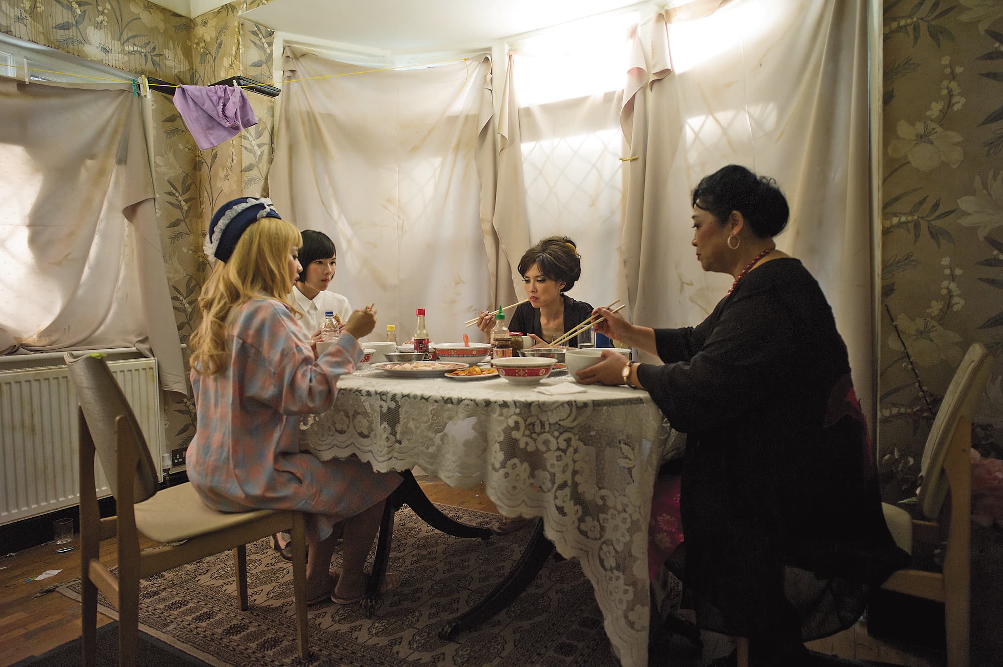 《接線員》場景比照真實按摩院,用布遮住窗戶避免查緝,左起為飾演按摩女的范時軒、紀培慧、陳湘琪與演老鴇的卓見。 (鏡象電影提供)