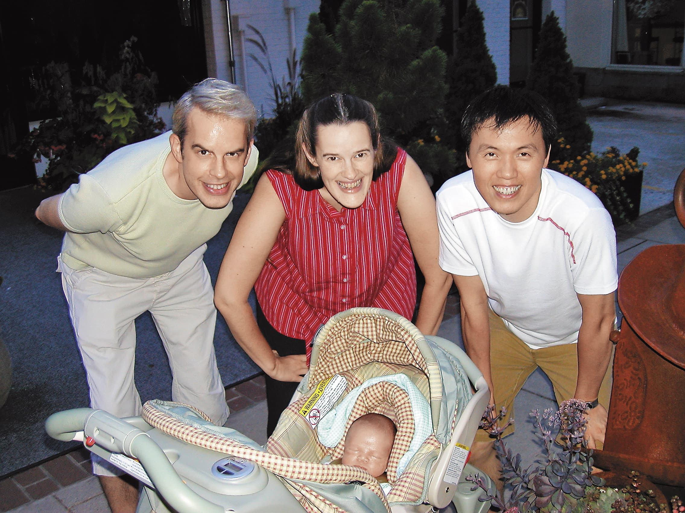 2003年,愷樂在北卡的Asheville剛出生不久,陳子良(右)、思鐸(左)及代理孕母艾莉森(中)第一次帶小孩出門溜搭。(陳子良提供)