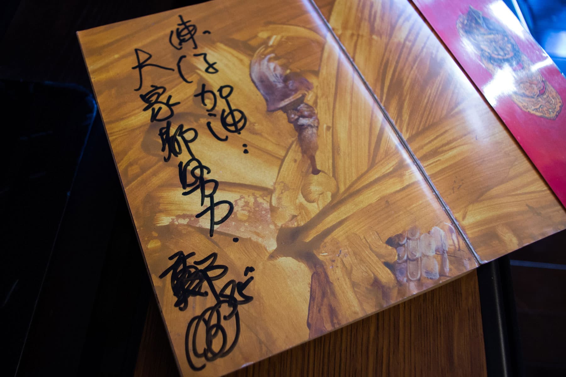 鄭問在書上題字鼓勵練任。練任笑說,老師每次簽書送徒弟,寫的都是「加油」,鼓勵大家繼續創作。(周文凱攝)