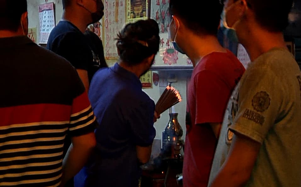 上門嗆聲的信徒試圖把香爐裡的香拔走,遭廟方人員奪回。