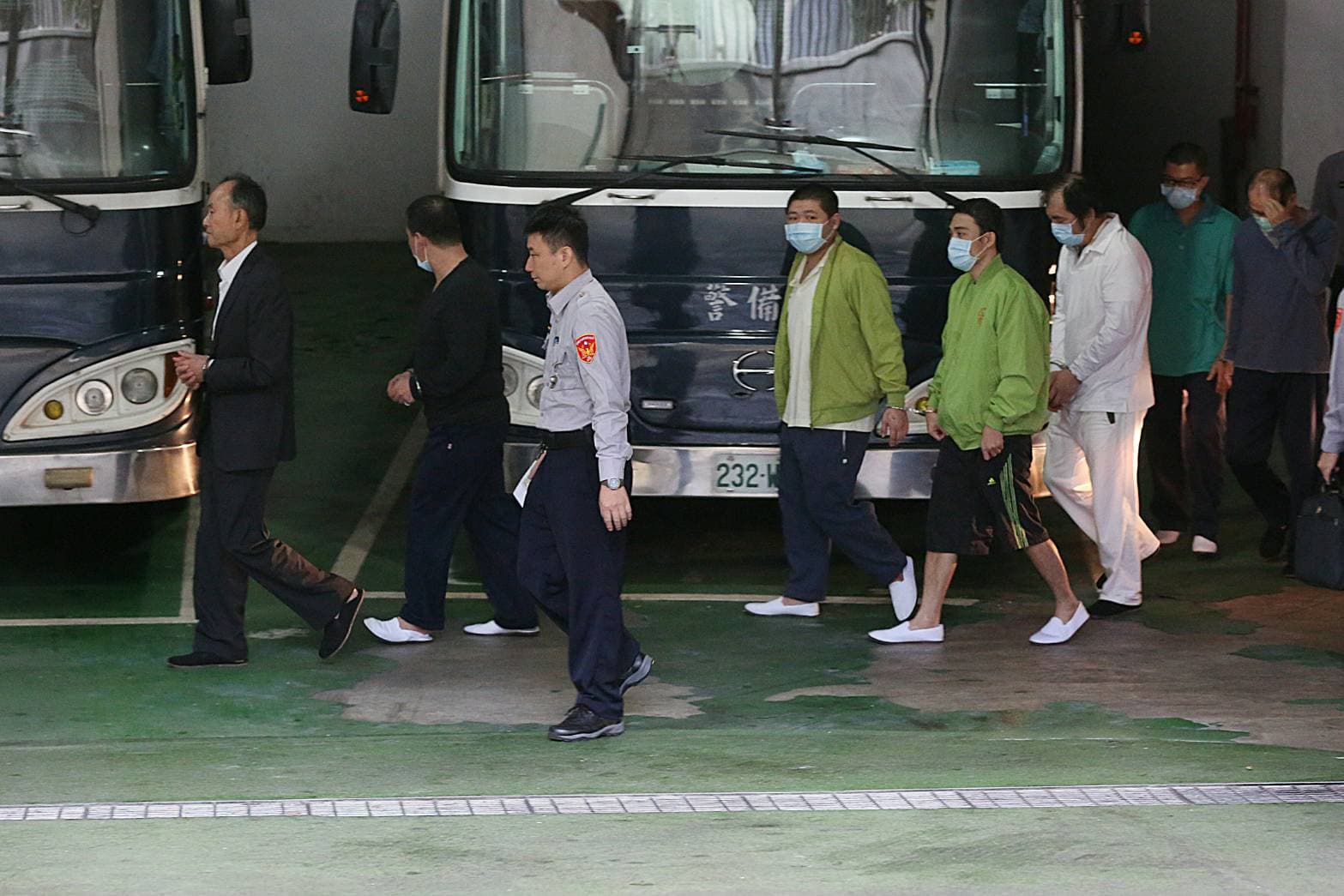 新北市議員周勝考(著白衣)及前營建署主秘洪嘉宏(遮臉者)也被提訊。