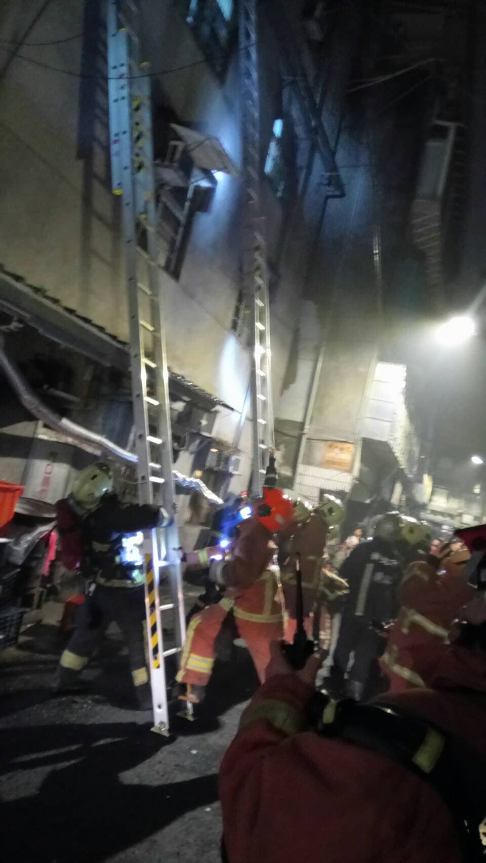 消防人員布水線與雲梯搶救火勢。(警方提供)