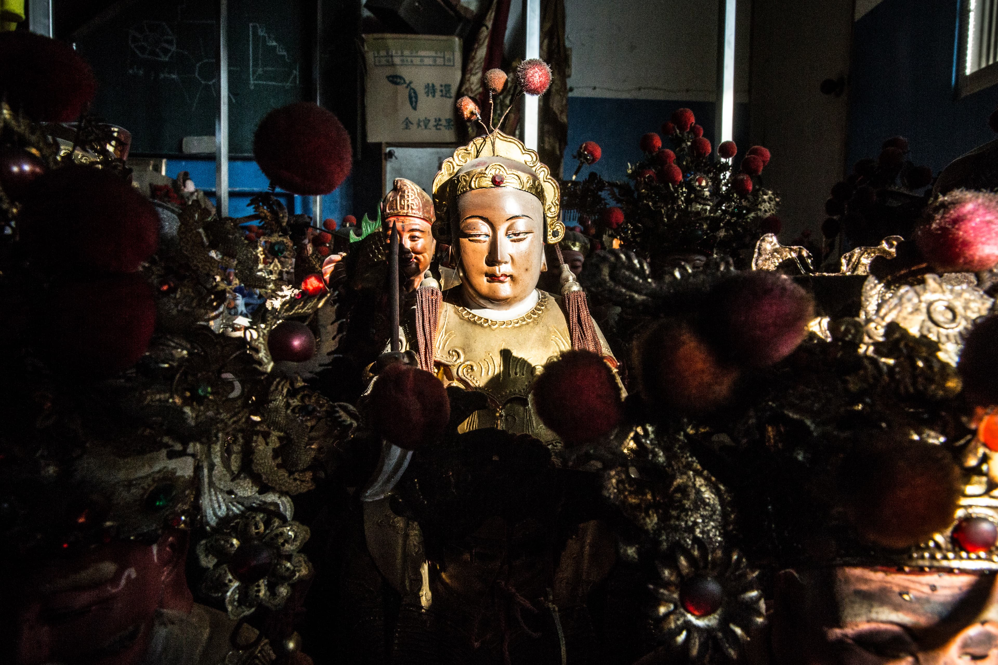 華麗的頭冠、披巾裝飾,以及身軀上金光閃閃的金漆,都是一尊神明曾經香鼎盛,信徒眾多的證明,但仍面對落難的結局。