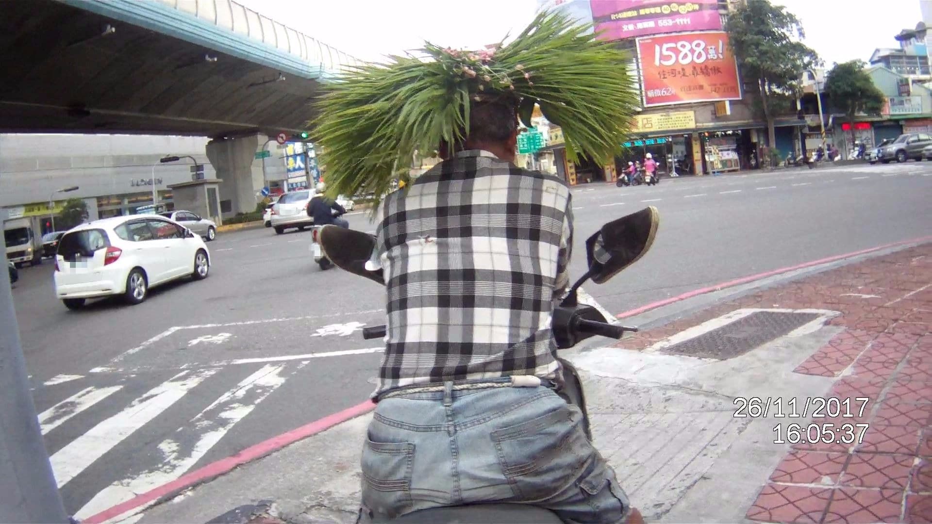 帶著自製草帽馬路騎車反而太醒目, 遭警攔開單。(警方提供)