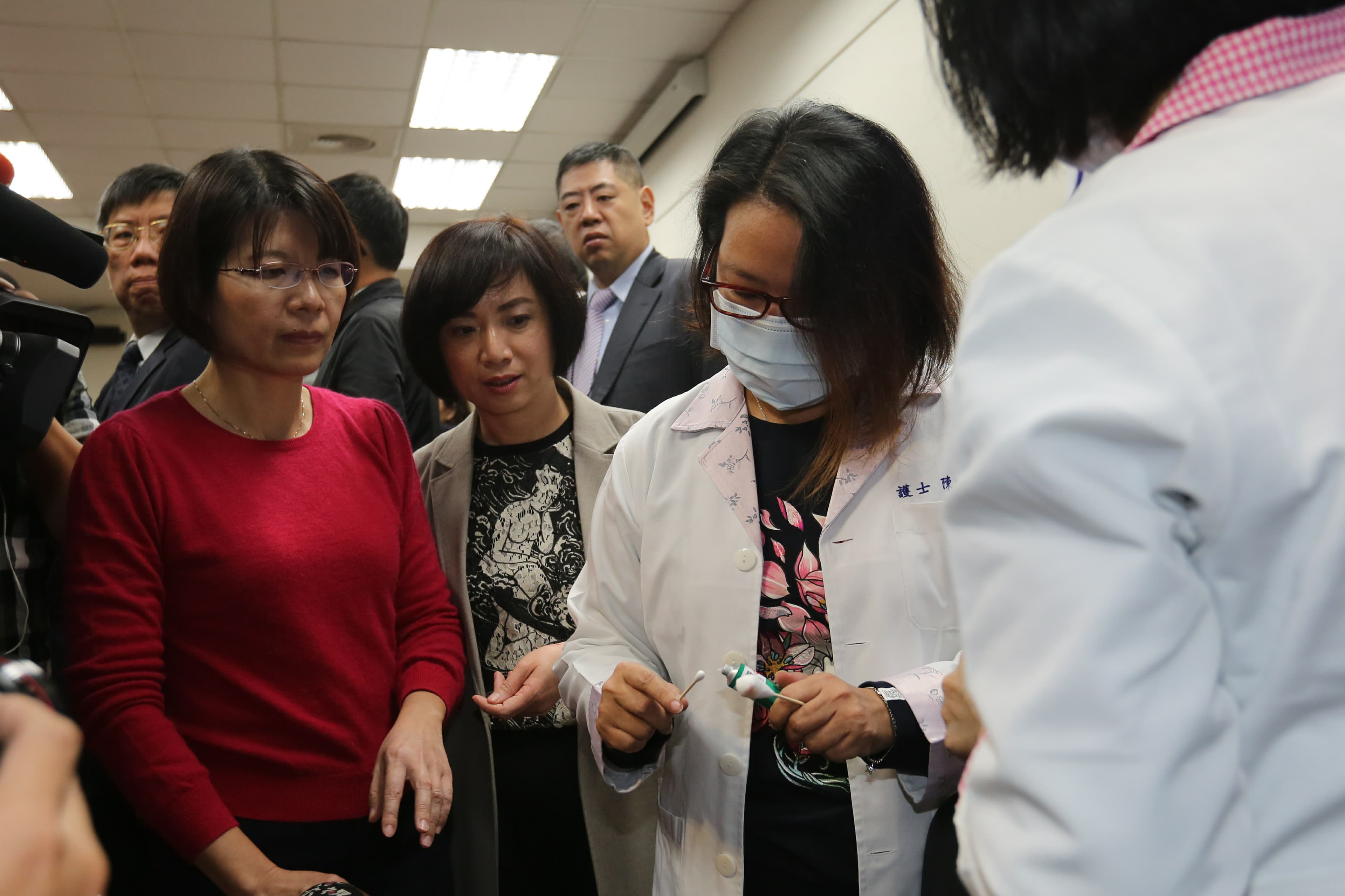 民進黨立委黃秀芳(右1)、何欣純(右2)在推擠衝突中受到皮肉傷,立法院醫務室派人為2人擦藥。