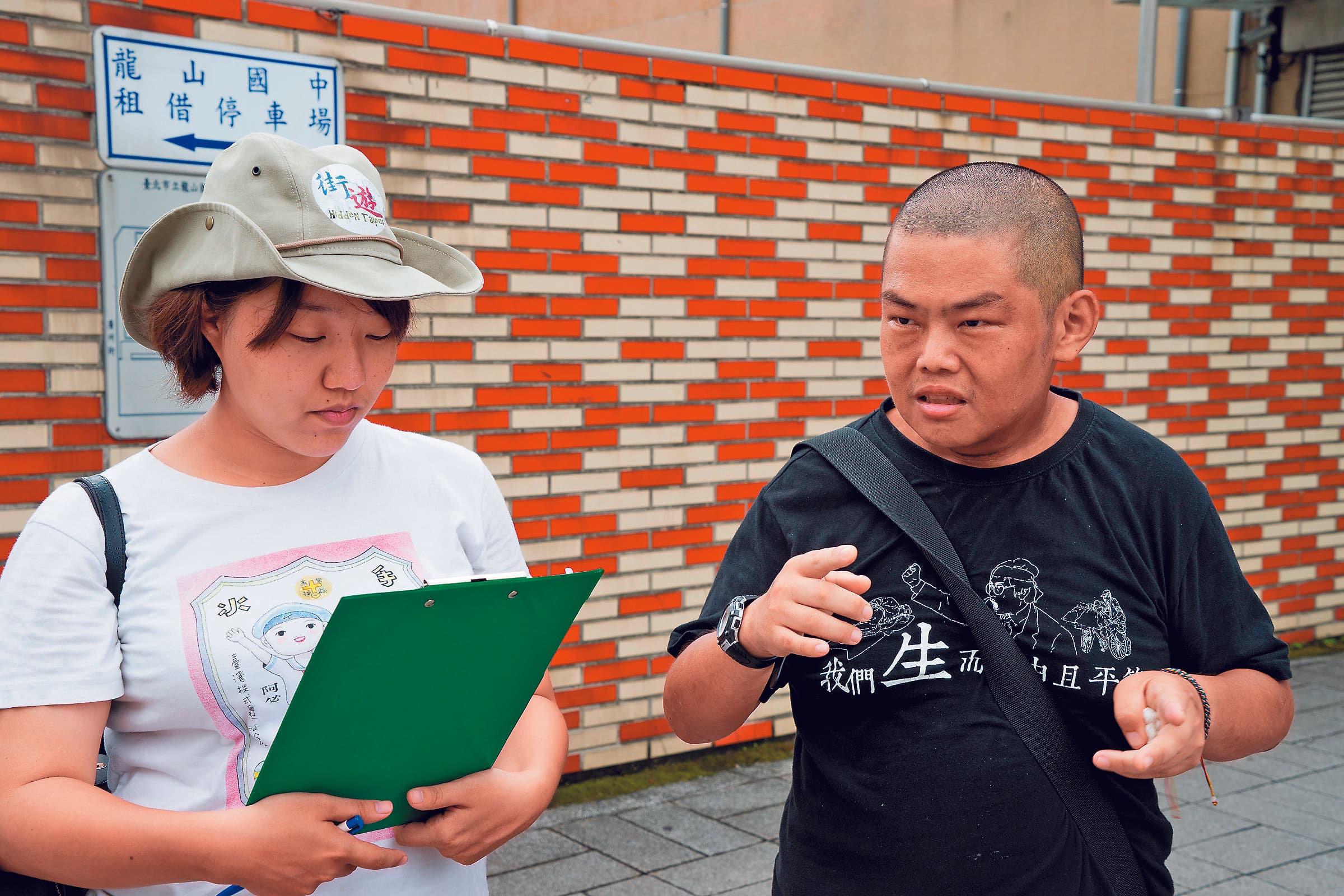 社工李佳庭(左)的工作是培訓遊民成為街遊導覽員。右為導覽員小胖,去年10月因心肌梗塞過世。(李佳庭提供)