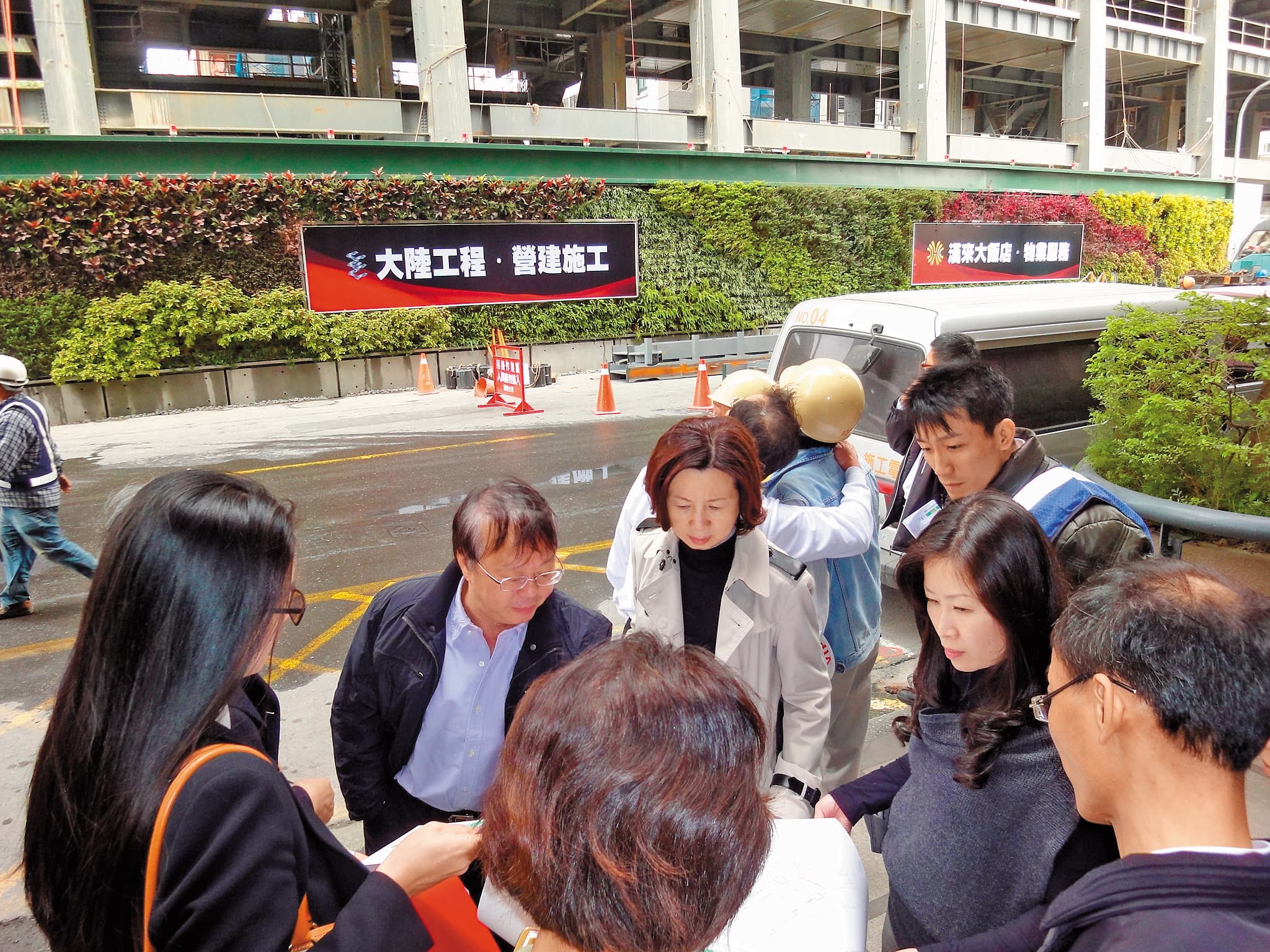 在國揚建設待了10多年,王翠瑛(右2)很佩服創辦人侯西峰(左2)的數字和管理能力,讓她受益良多,後方為國揚興建的高雄豪宅「國硯」工地現場。(王翠瑛提供)