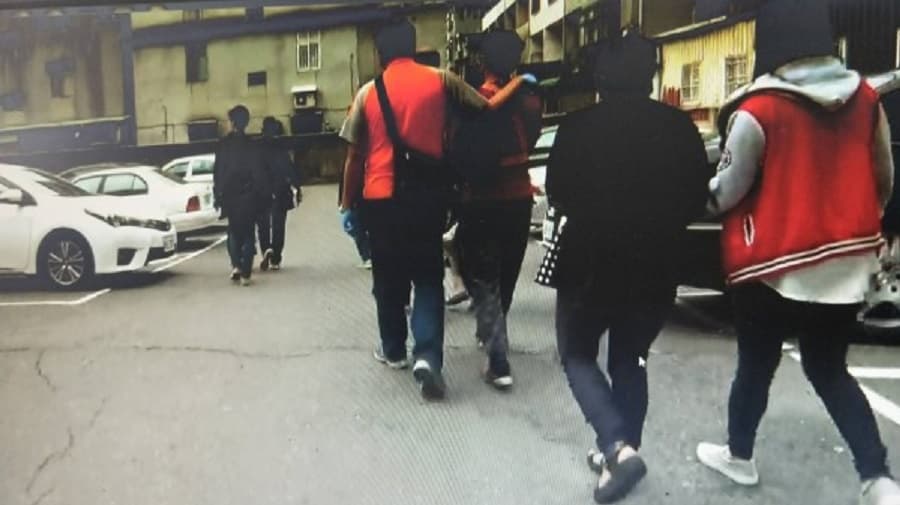 警方在賓館的停車場押解落網的毒蟲們準備帶回分局訊問。(警方提供)