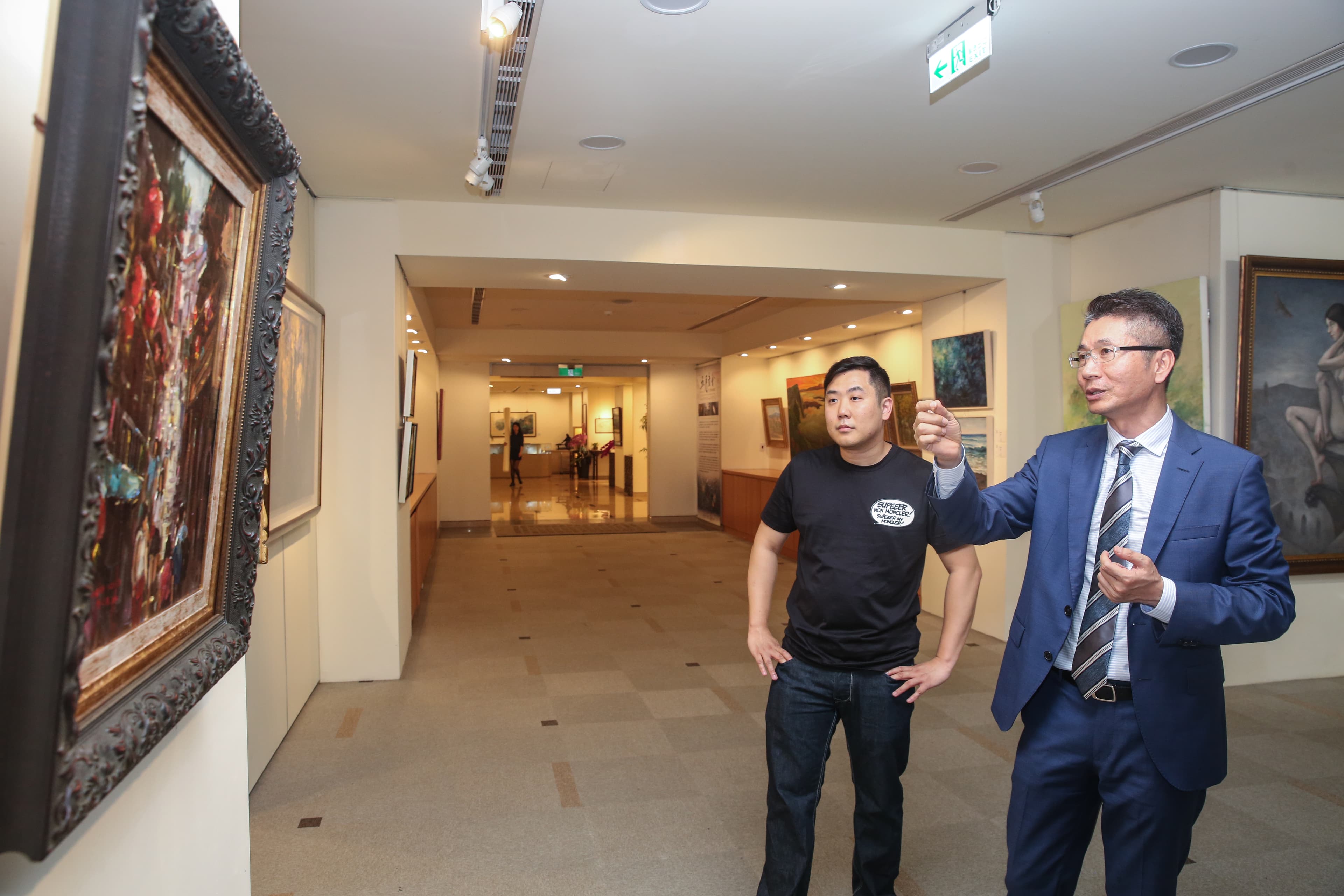 邑錡董事長陳世哲(右)親自參觀畫展,說明縮時相機的多元紀錄功能。