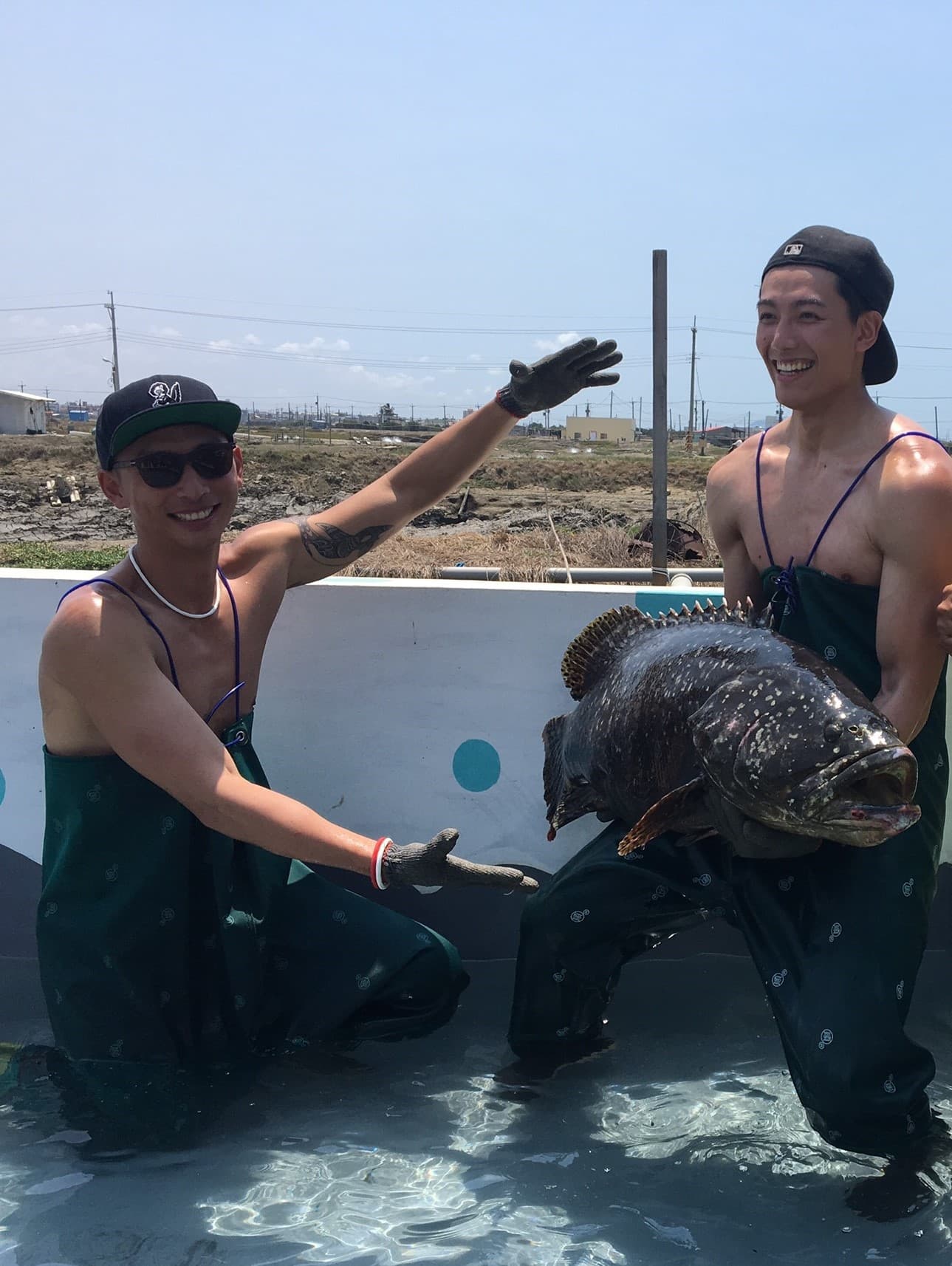 賴東賢(右)手上抱著龍膽石斑魚,畫面頗驚人。左為賴俊龍。(三立提供)