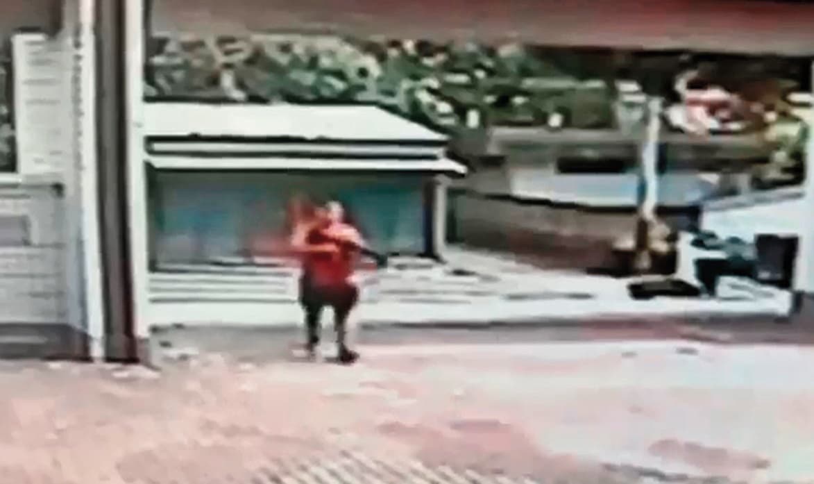 監視器畫面清楚看到江宇倫衝出校門瞄準完中輟生後,手持長槍走回校園。(翻攝畫面)