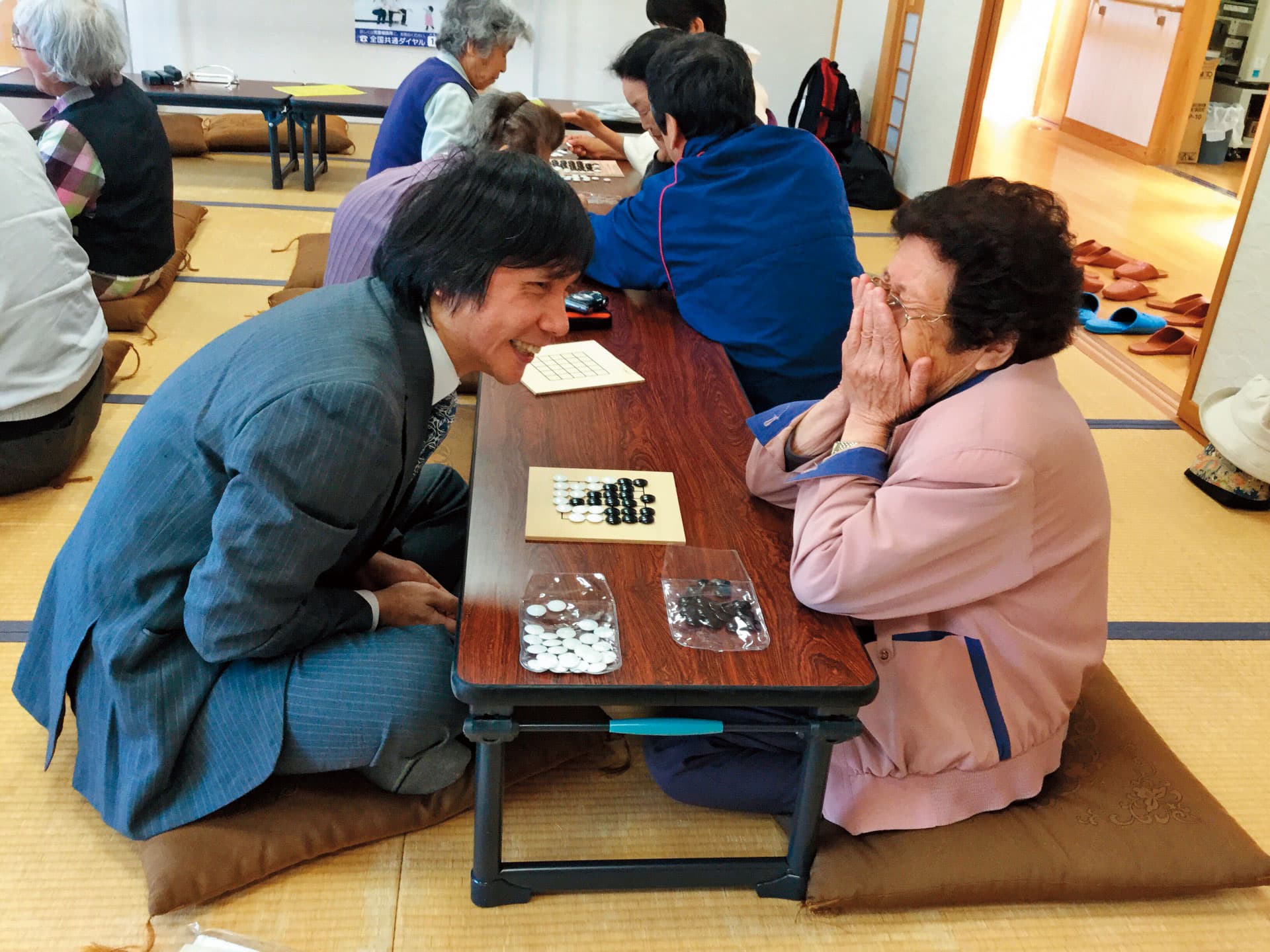 王銘琬近2年積極推廣純棋，號稱不論老小，10分鐘可學會。圖中的老奶奶，下棋下得不亦樂乎。（王銘琬提供）