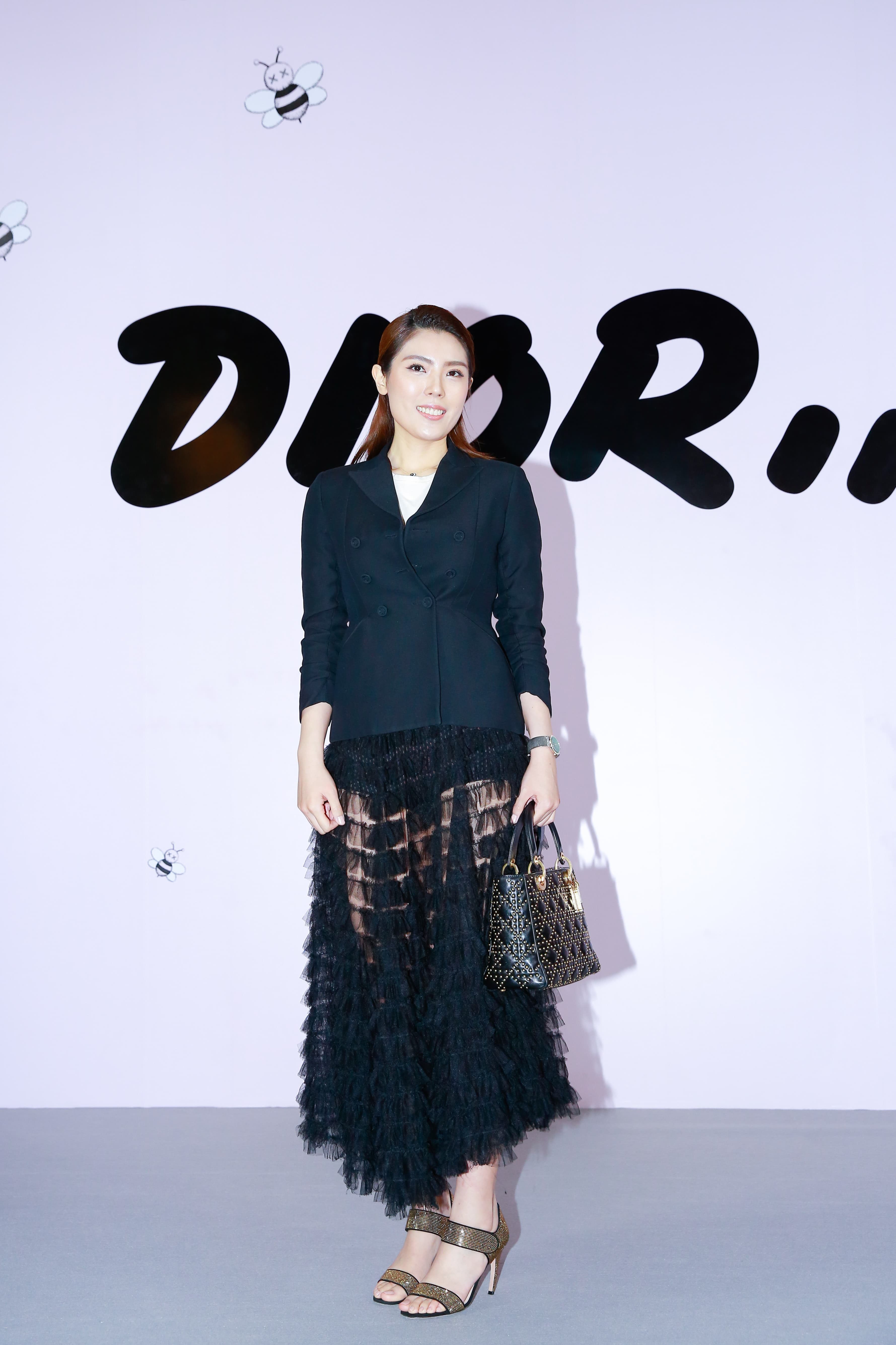 理科太太穿著Dior黑色Bar Jacket，NT$145,000；黑色透明蛋糕紗裙，NT$340,000；白色棉T，NT$24,000；黑色運動內襯褲，NT$32,000。