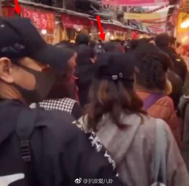 大稻埕人潮洶湧,吳奇隆全身包緊緊在劉詩詩身後保護愛妻。(翻攝自扒皮愛八卦微博)