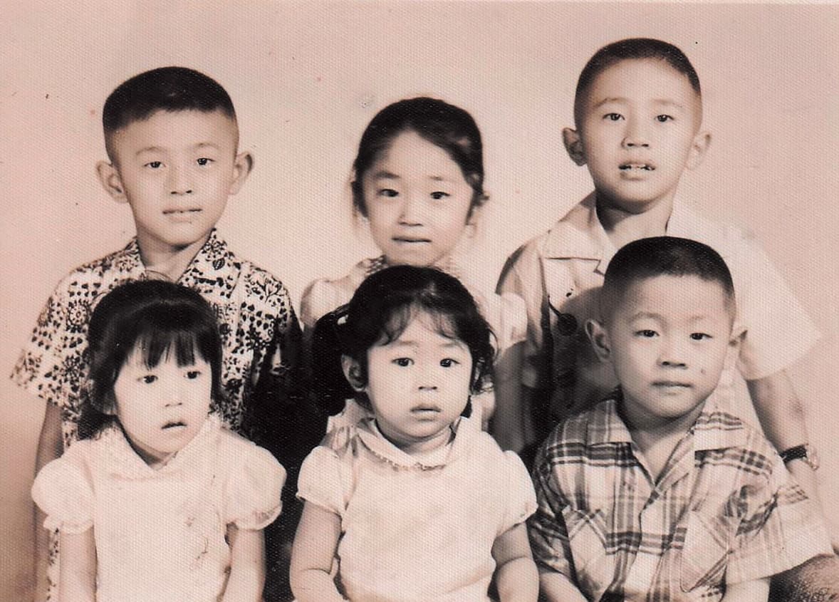 兒時店裡生意忙，曹愛琴（前排中）與手足被寄養在不同家庭，上小學後才一家團圓。（曹愛琴提供）