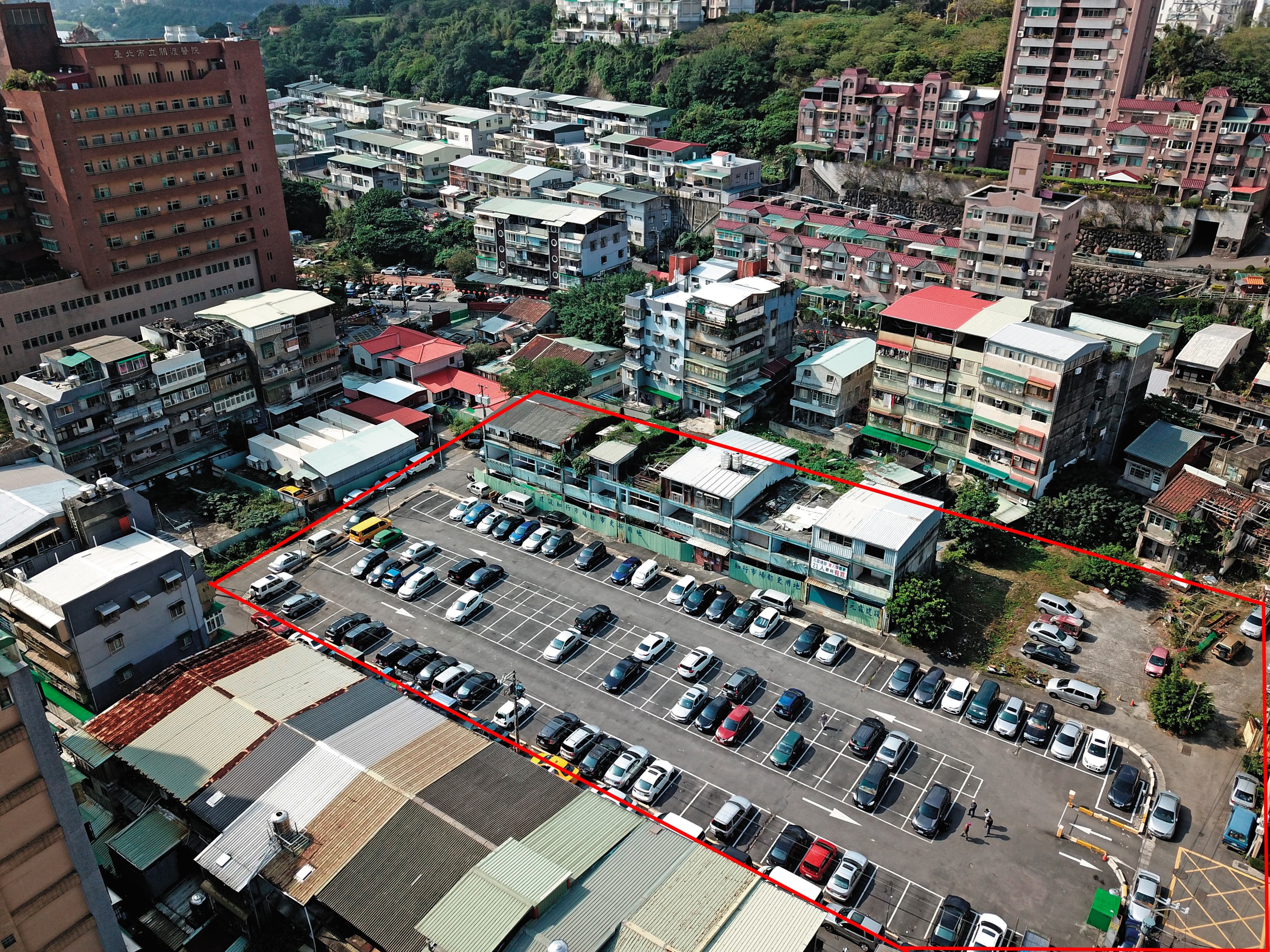 台北市關渡知行路都更案總面積約1,500坪(紅框處),緊鄰關渡醫院,因爆發灌人頭弊端,目前停擺中,大部分土地暫時闢為停車場。