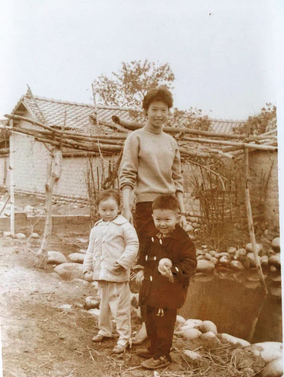 幼年的喜翔(前右)多在外婆家生活,圖為他露出調皮表情和姊姊(前左)、表姊(後)在霧峰林家的合照。(喜翔提供)