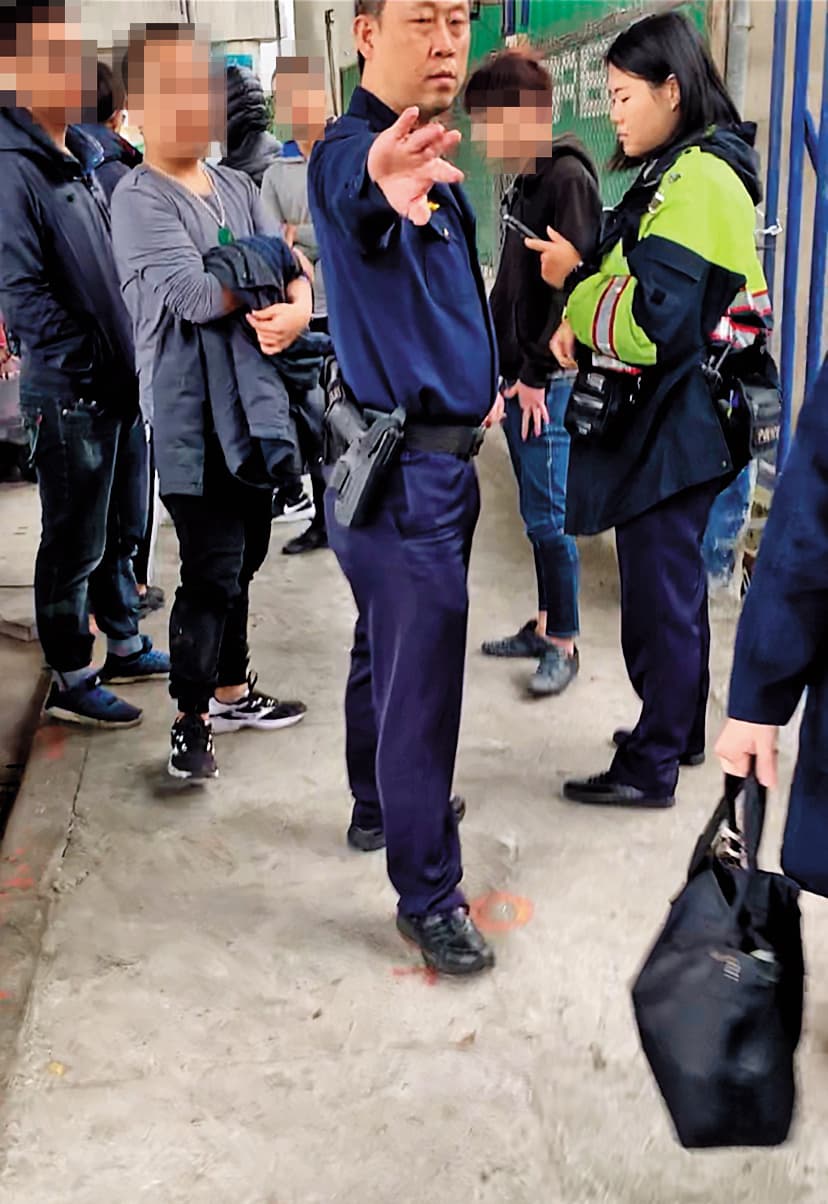 不明黑衣人士圍堵印北倉庫出入口,警方荷槍實彈不敢大意。(讀者提供)