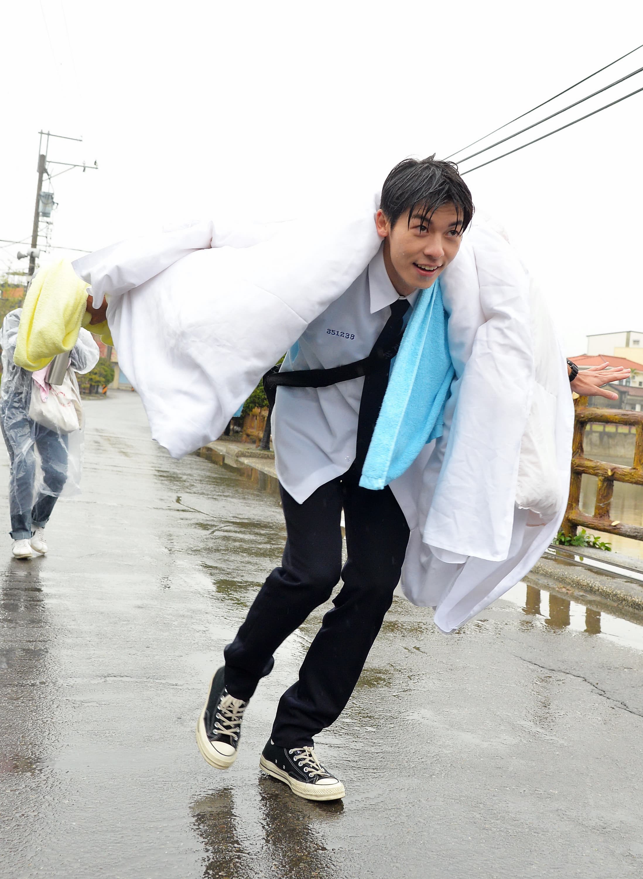 許光漢在大雨中披棉被走秀裝名模。(福斯傳媒集團提供)