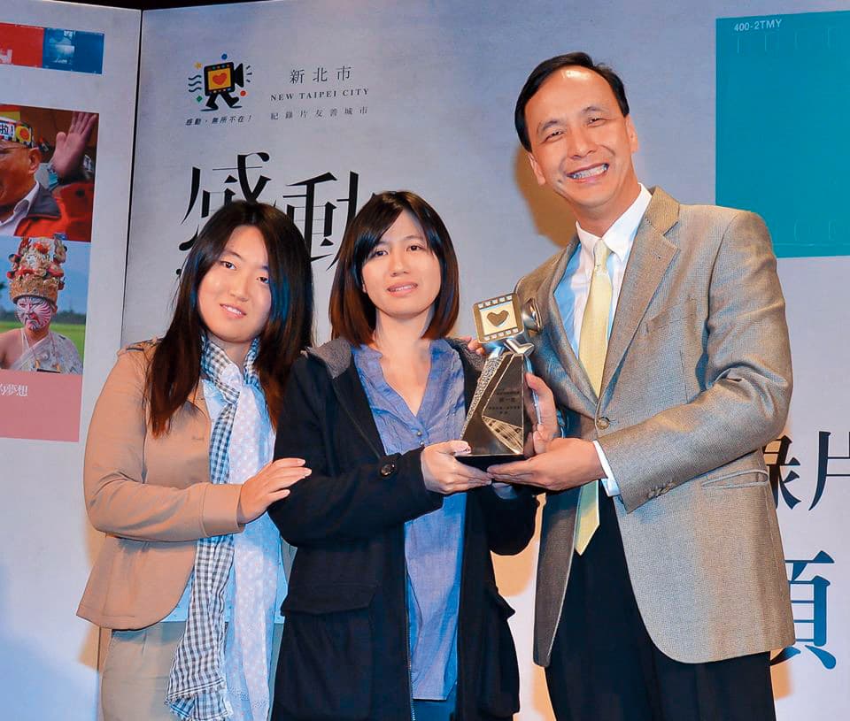 以在台陸生蔡博藝(左起)為傳主的《我在台灣,我正青春》獲新北市紀錄片奬首獎,傅榆從當時市長朱立倫(右)手中接下獎座。(翻攝自新北市紀錄片系列活動臉書)