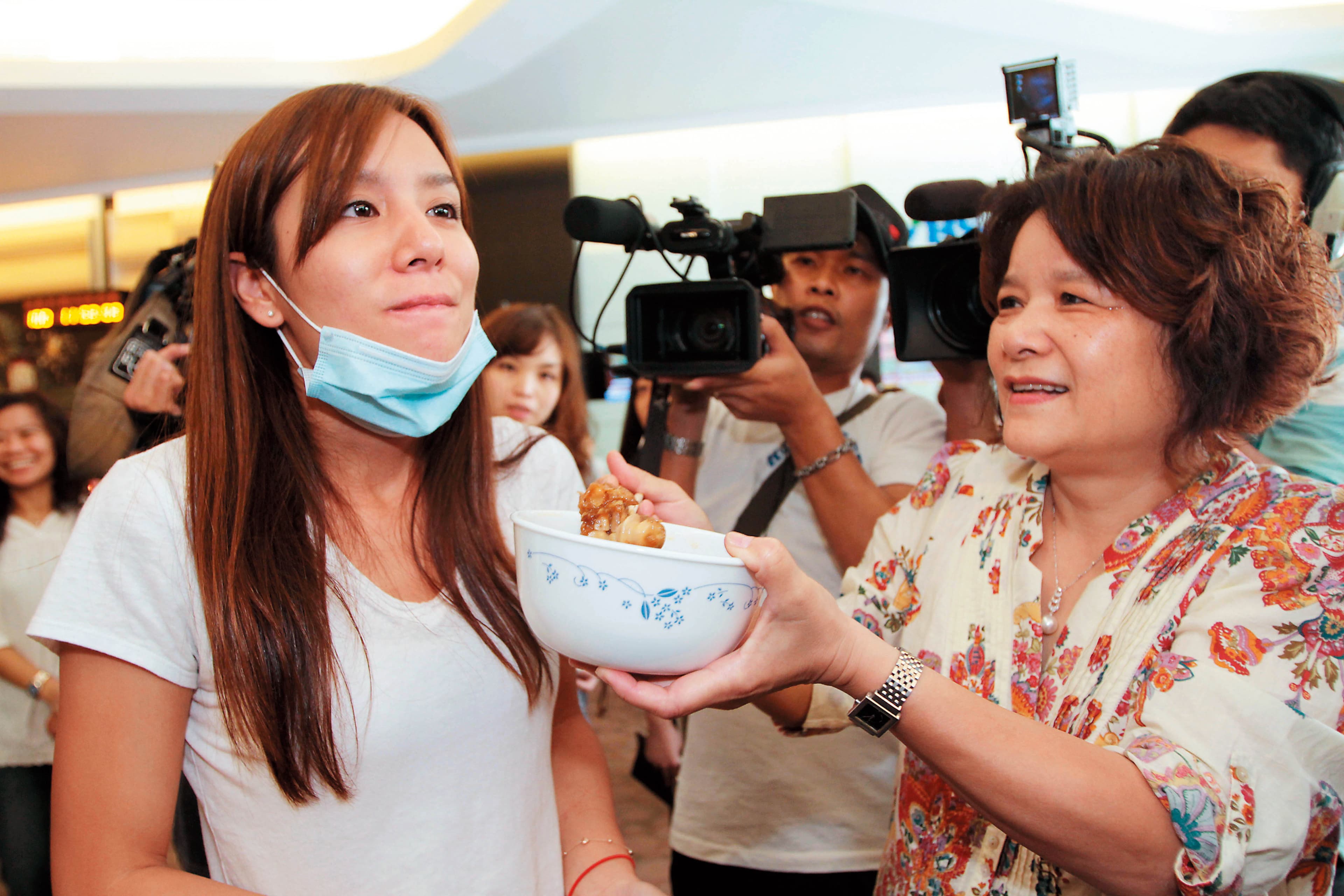 2010年前往印度拍攝外景,意外遭遇槍擊掃射,急忙提前返台,媽媽(右)特別在機場餵莎莎吃豬腳麵線。(東方IC)