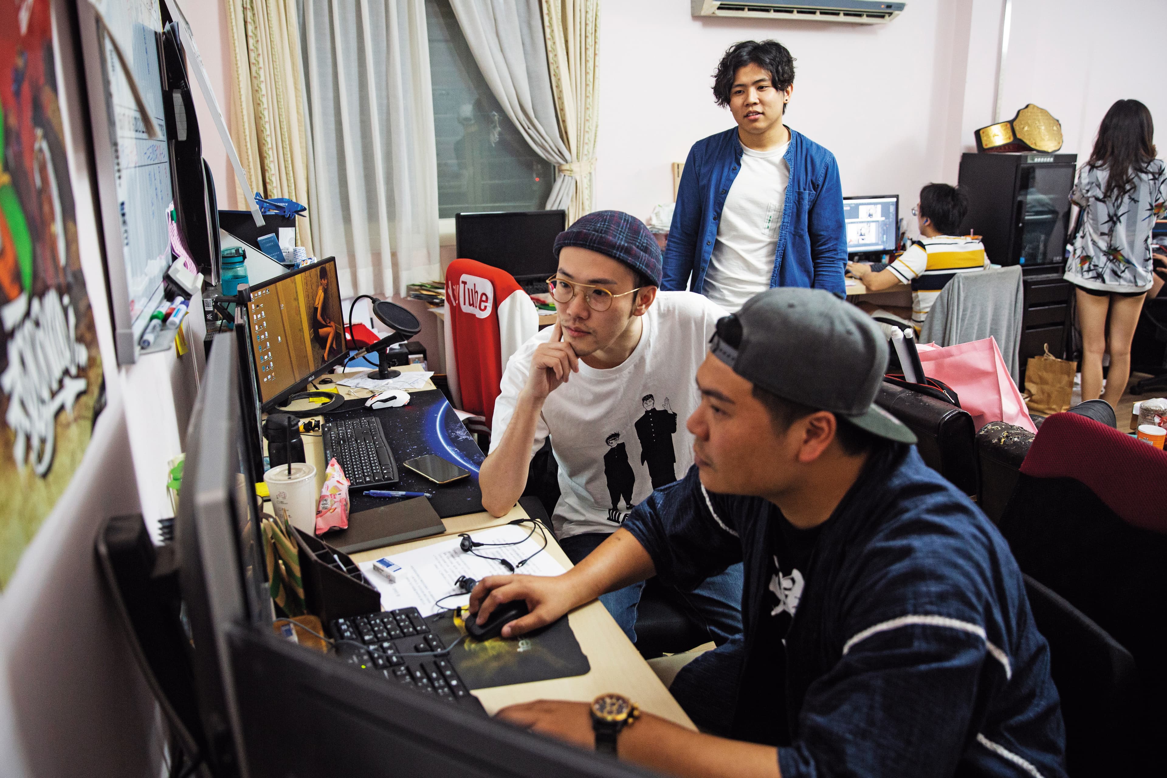 華森(中)和夥伴鐵牛(前)在辦公室剪片,他們2人也是「頑game」的常駐演員。