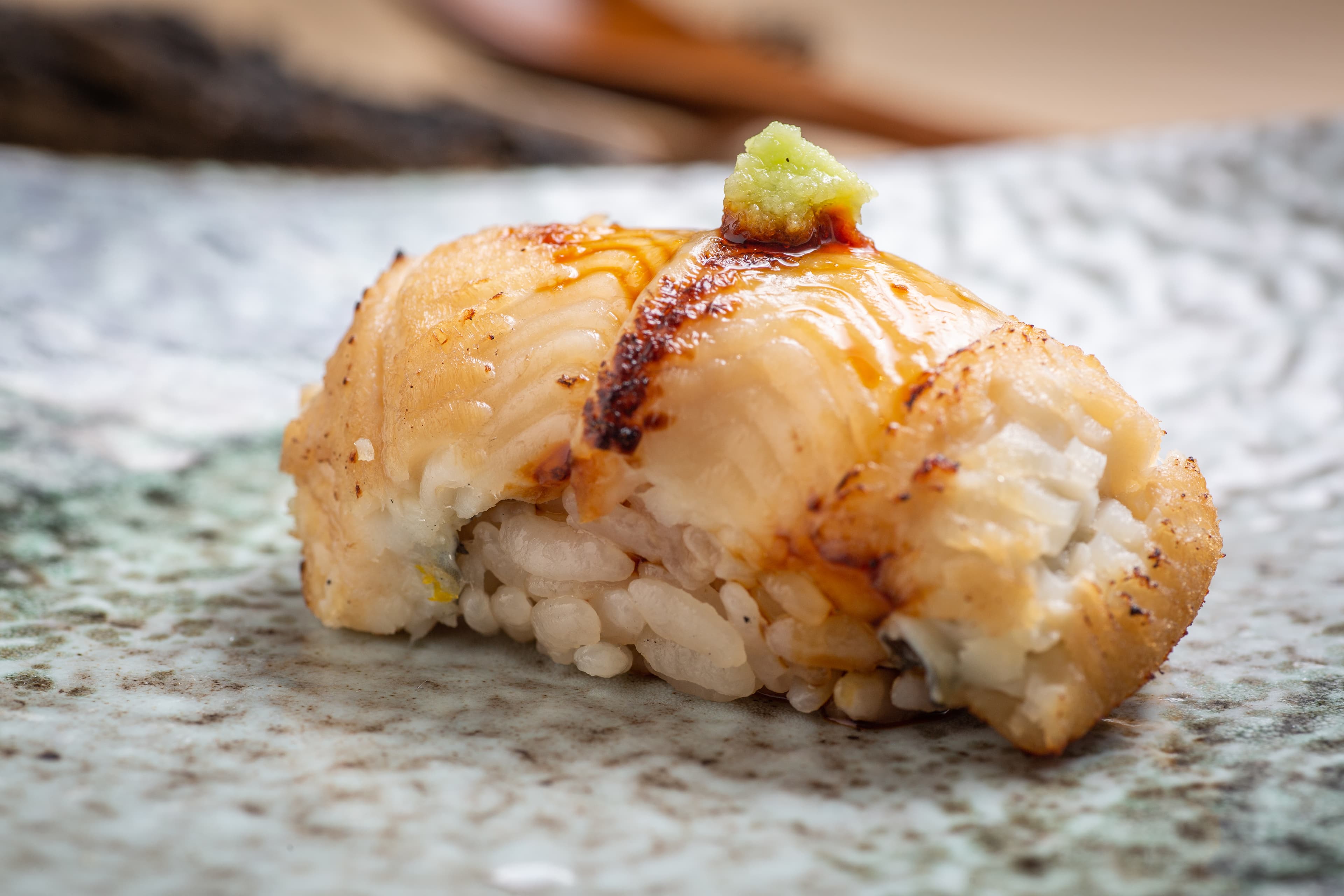 「烤星鰻壽司」淋上用星鰻魚骨熬成的醬汁,肉質溫熱化口,滋味甘鹹濃醇。